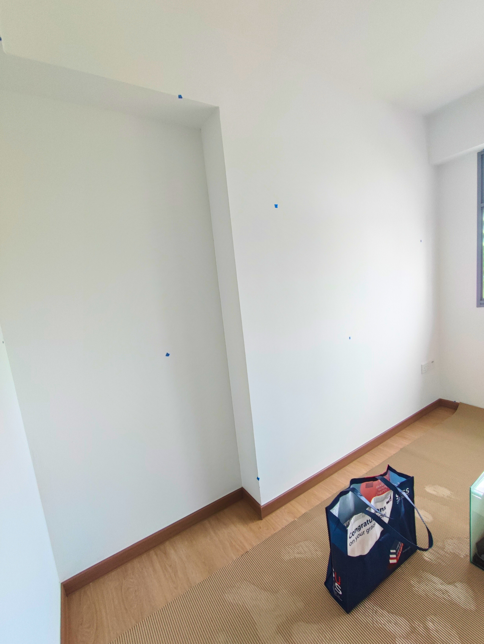 The Evolution Of My Home Gym From A Makeshift Kitchen - White walls, wooden floor, blue painter's tape, empty room, no