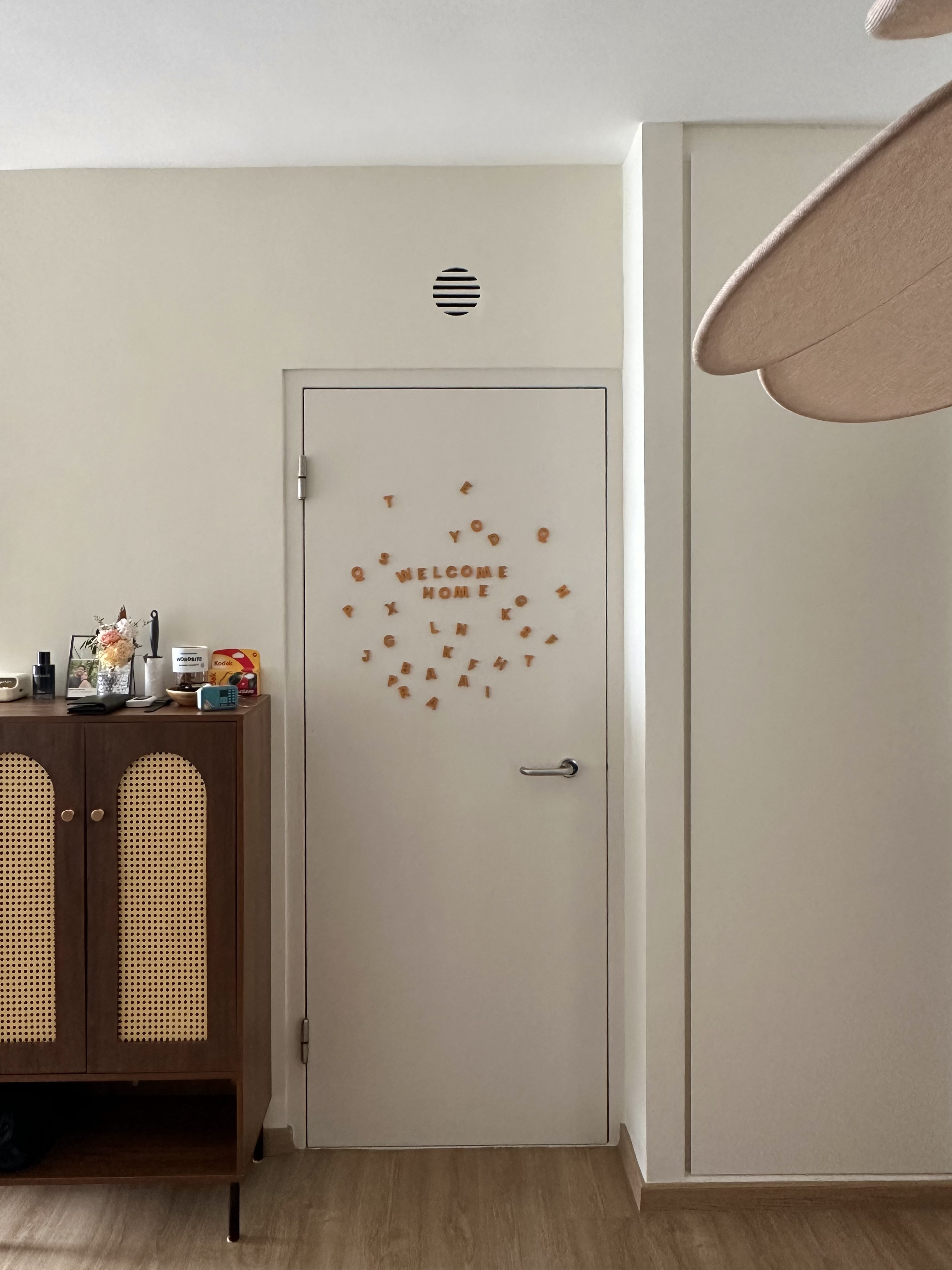 Our Simple Entryway with No Built-Ins - Wooden cabinet, beige wall, decorative letters, "Welcome Home" sign, wooden letters