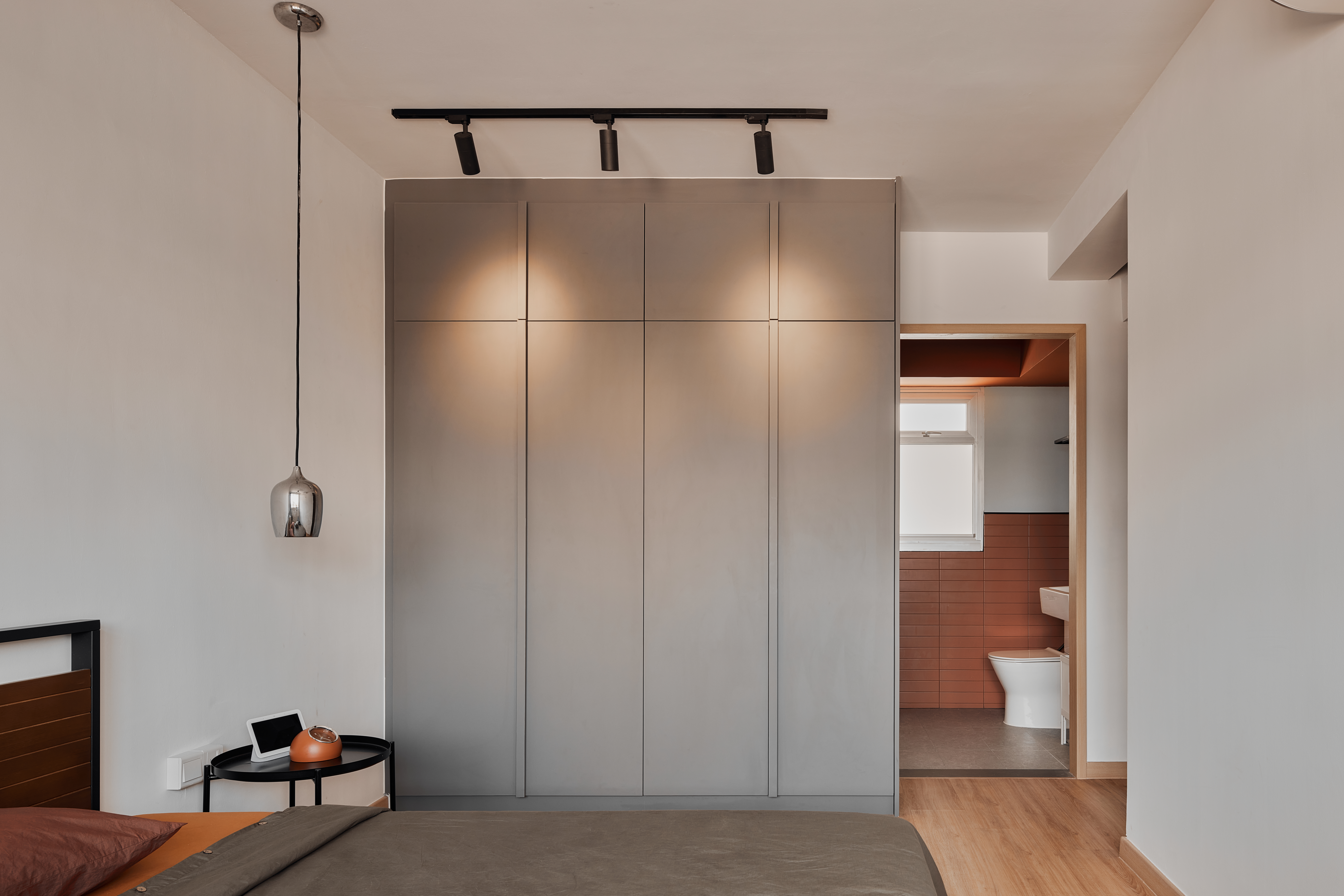 Before & After: Creating a Cozy Bedroom - Modern minimalist bedroom with sleek gray wardrobe, pendant light fixture, wooden