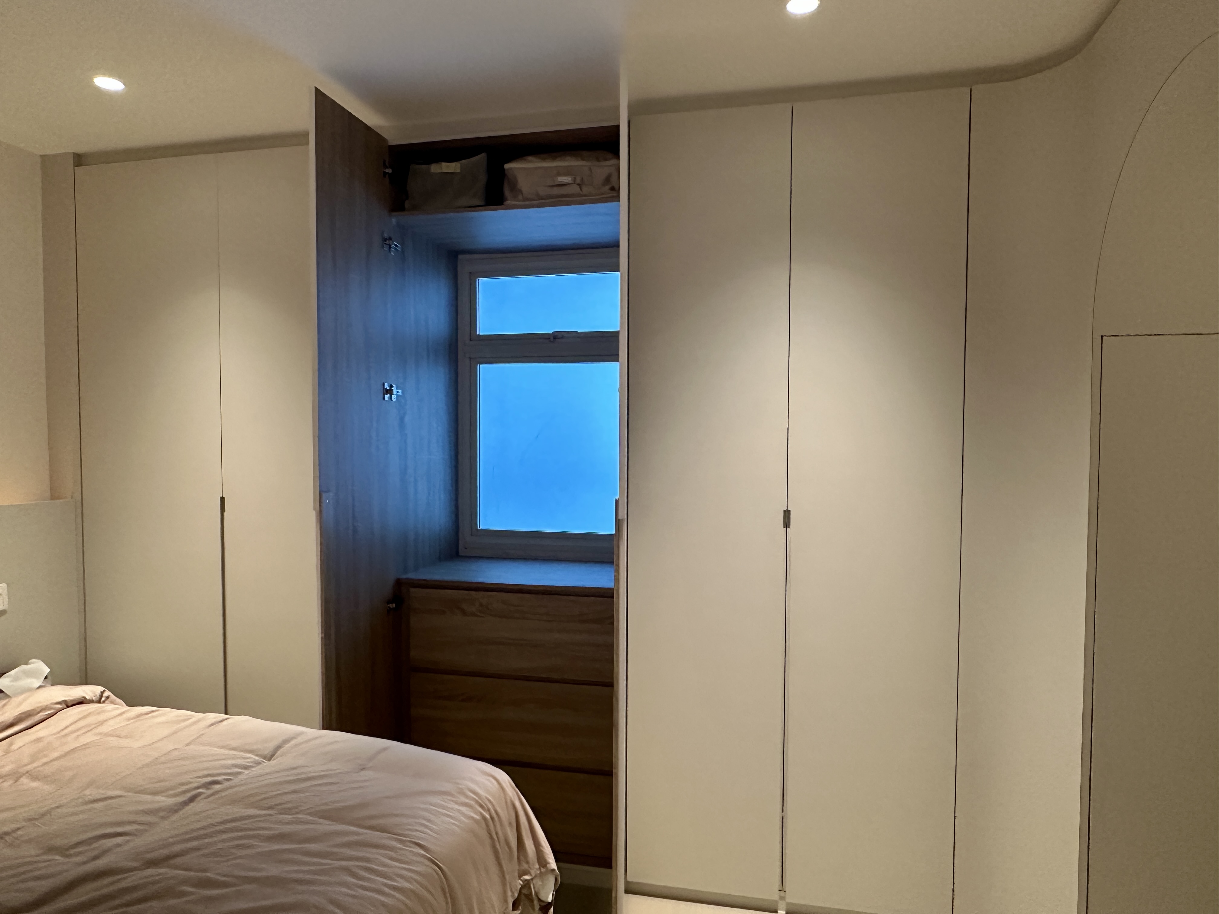 From Resale to Refined: Our $90K Functional Aesthetic HDB Makeover - Wooden wardrobe, beige bedding, window with blue sky