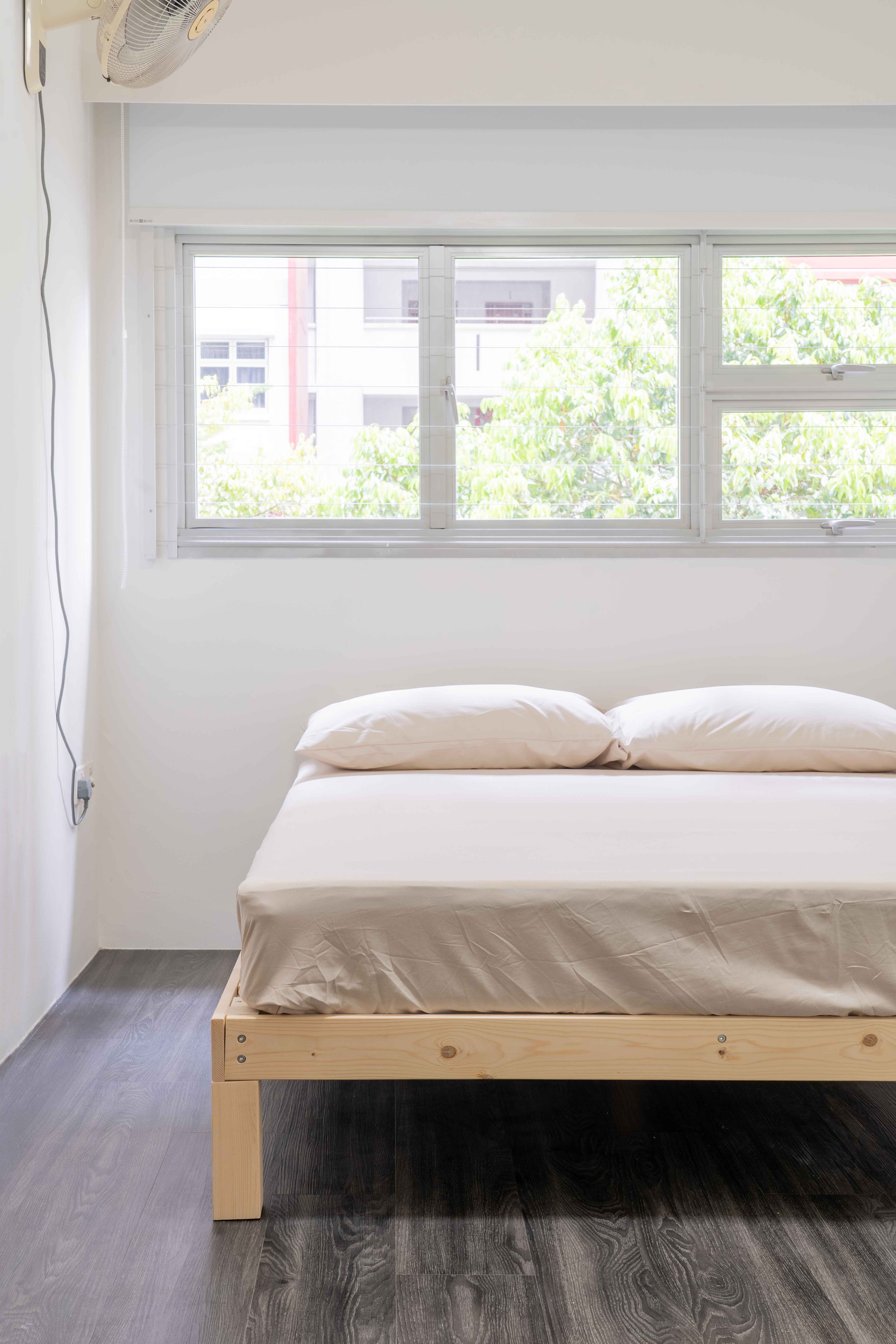 Minimalist Home With A Bright Airy Feel - Minimalist bedroom with large window, natural light, white walls, wooden bed frame