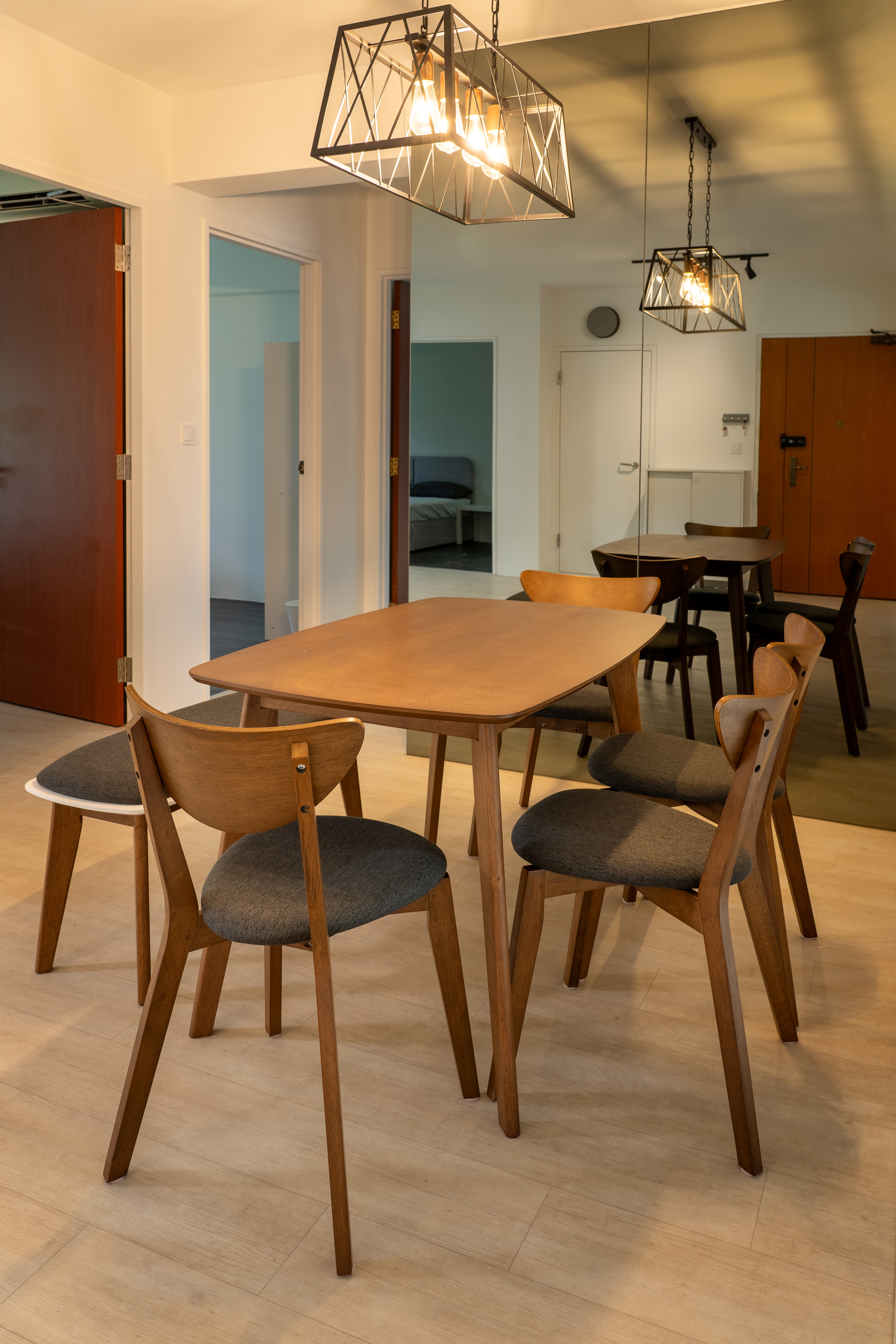 Minimalist Home With A Bright Airy Feel - Modern dining room with wooden table and chairs, geometric pendant lights