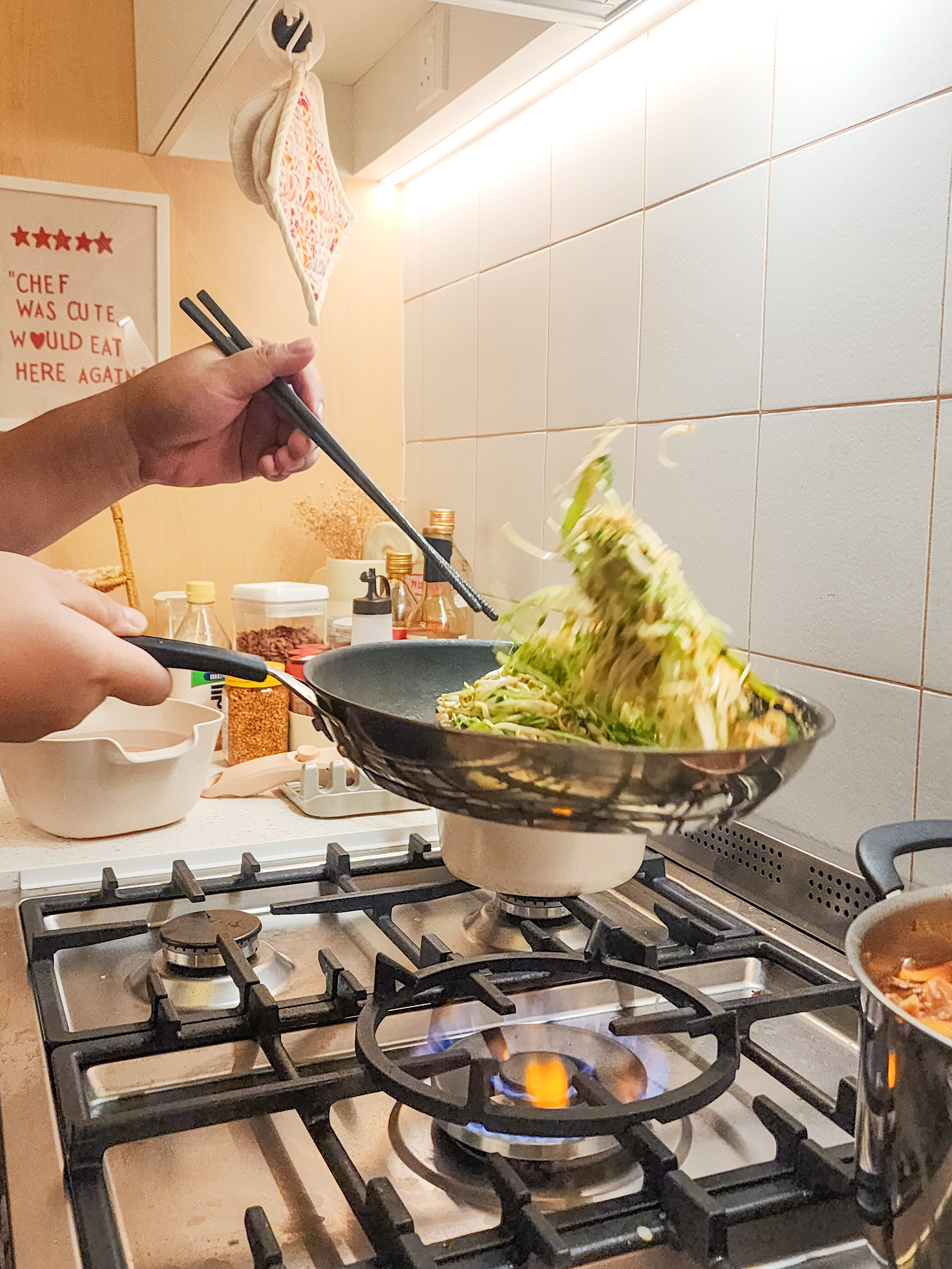 Step inside a chef's kitchen - closed concept, functional & aesthetic - stir fry, green vegetables, cooking, pan, stove, gas