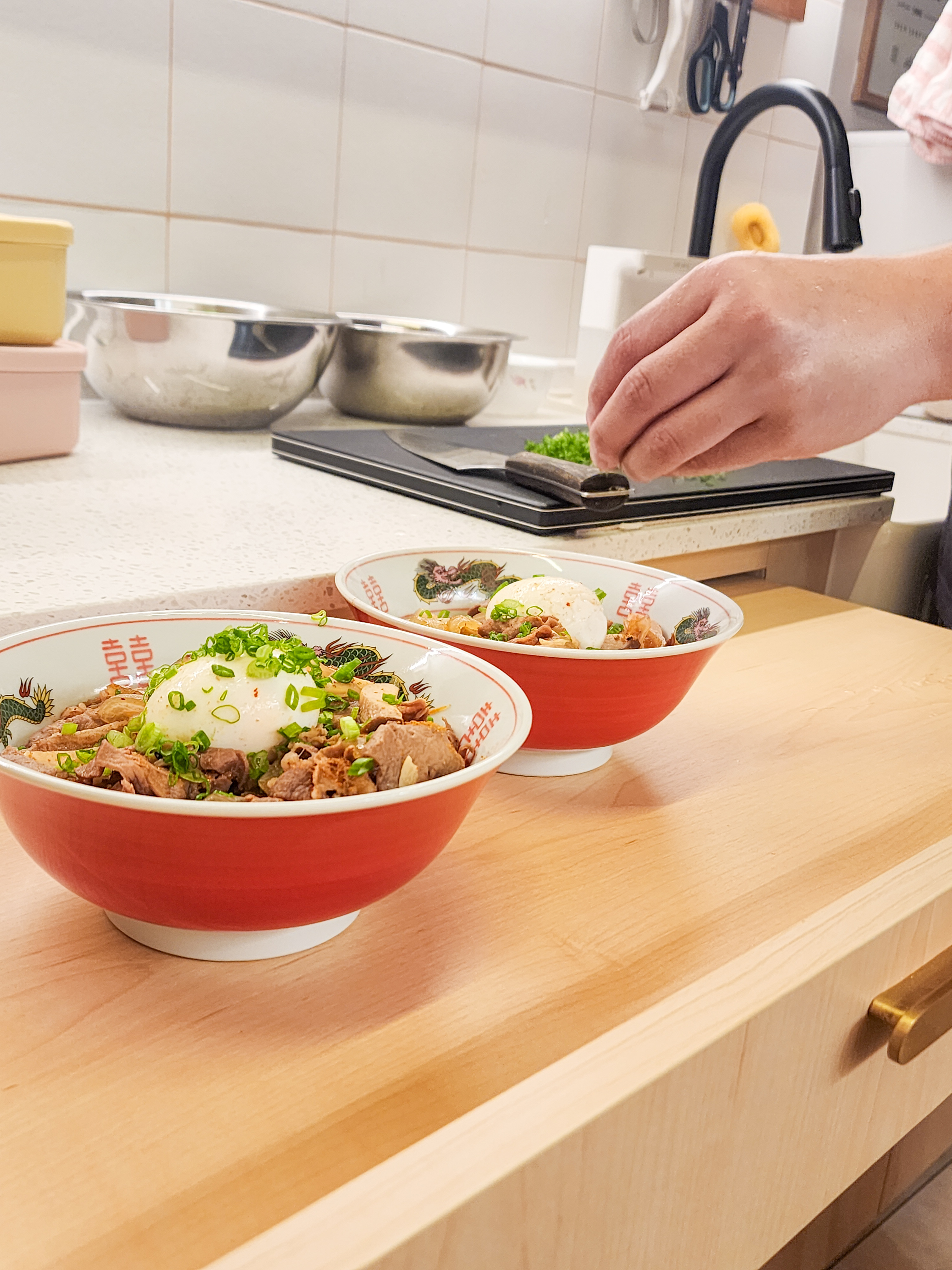 Step inside a chef's kitchen - closed concept, functional & aesthetic - Red and white bowl filled with stir-fried meat and