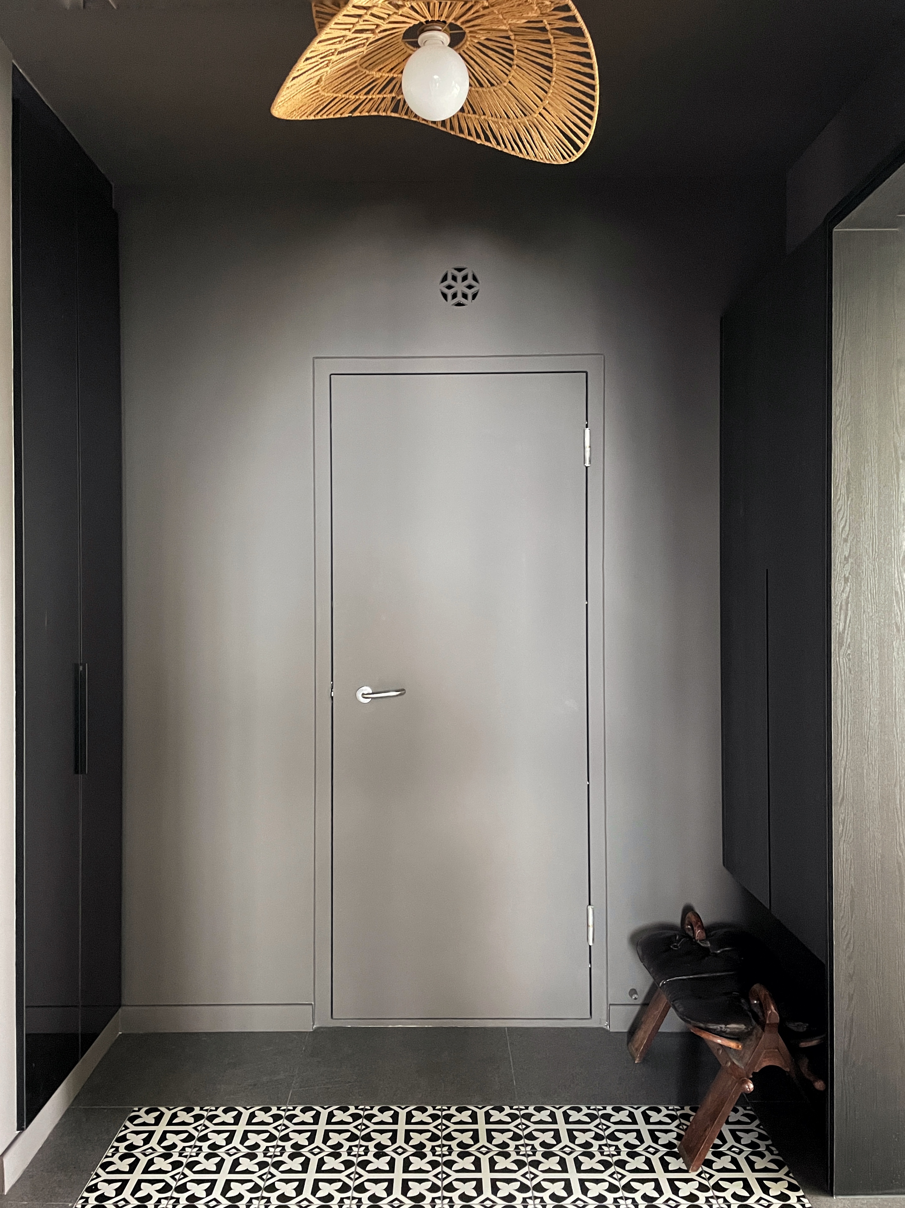 Entryway: A dark, moody space Decompression Chamber - modern minimalist interior, sleek door, dark gray walls, geometric