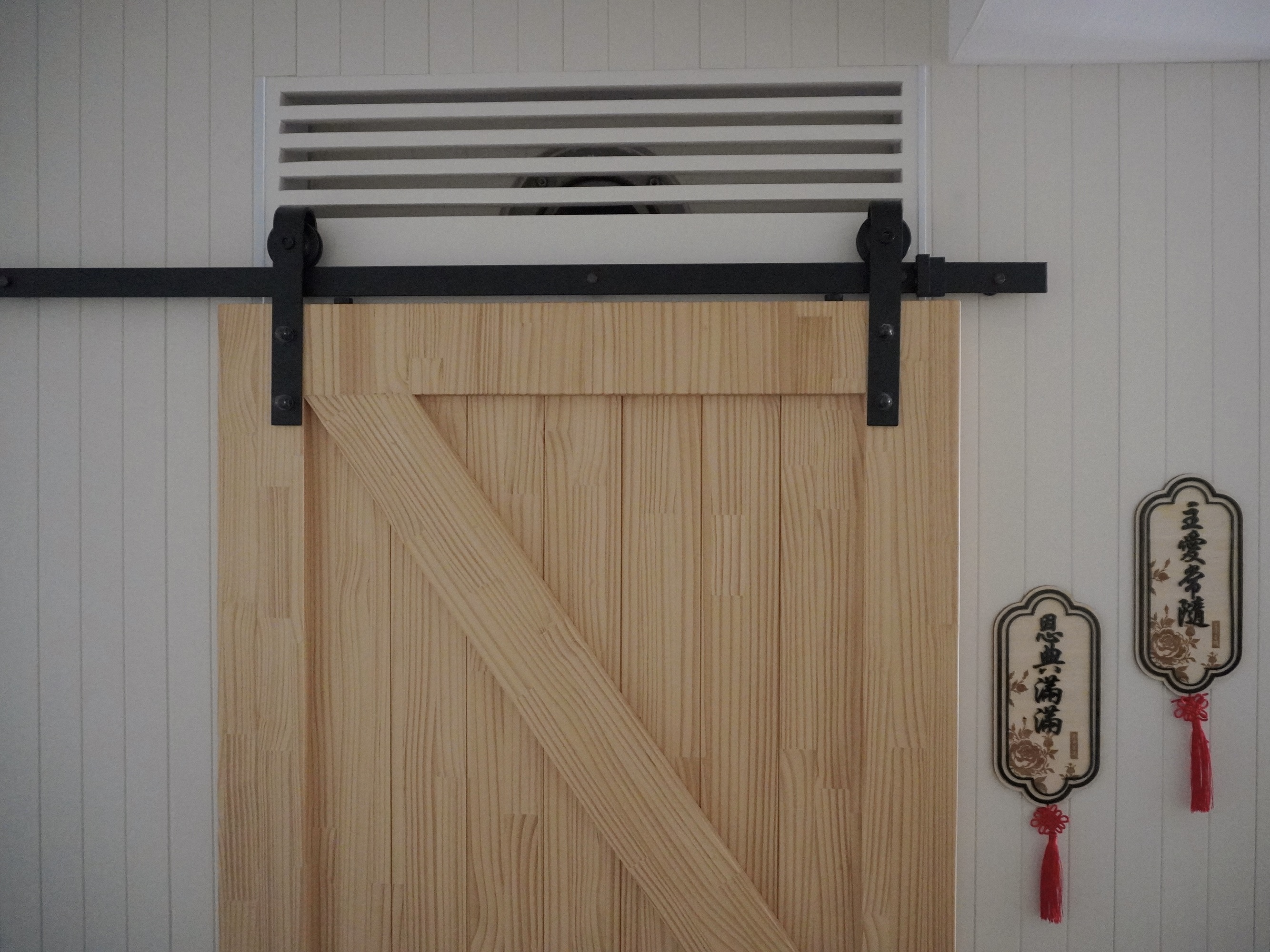 Earthy Entryway with Pops of Color: Ditching the built-in shoe cabinet - Wooden door with black metal frame, white wall with