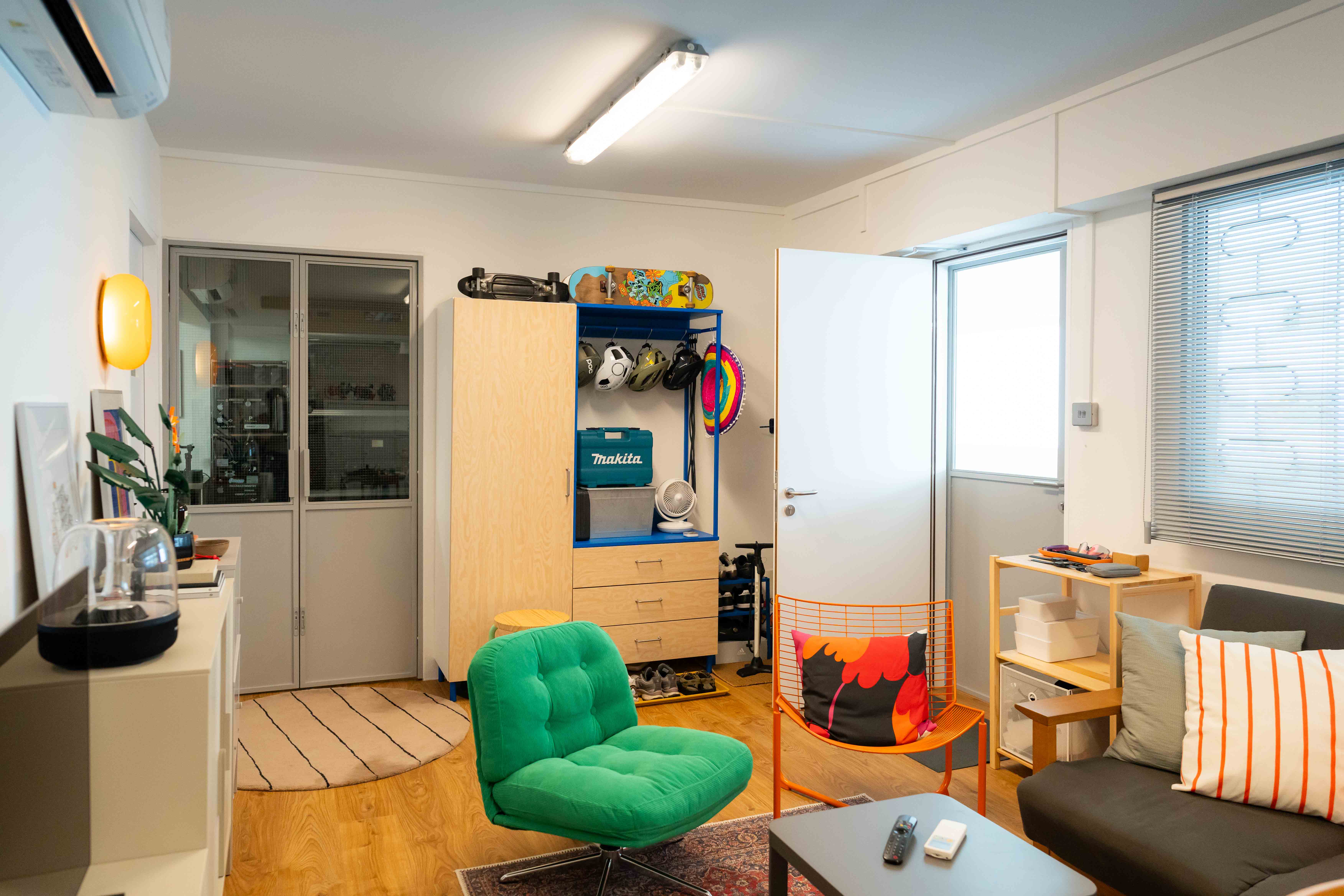 A colourful entryway with vibrant hues and a sporty vibe! - Modern living room with wooden floor, white walls, and a large