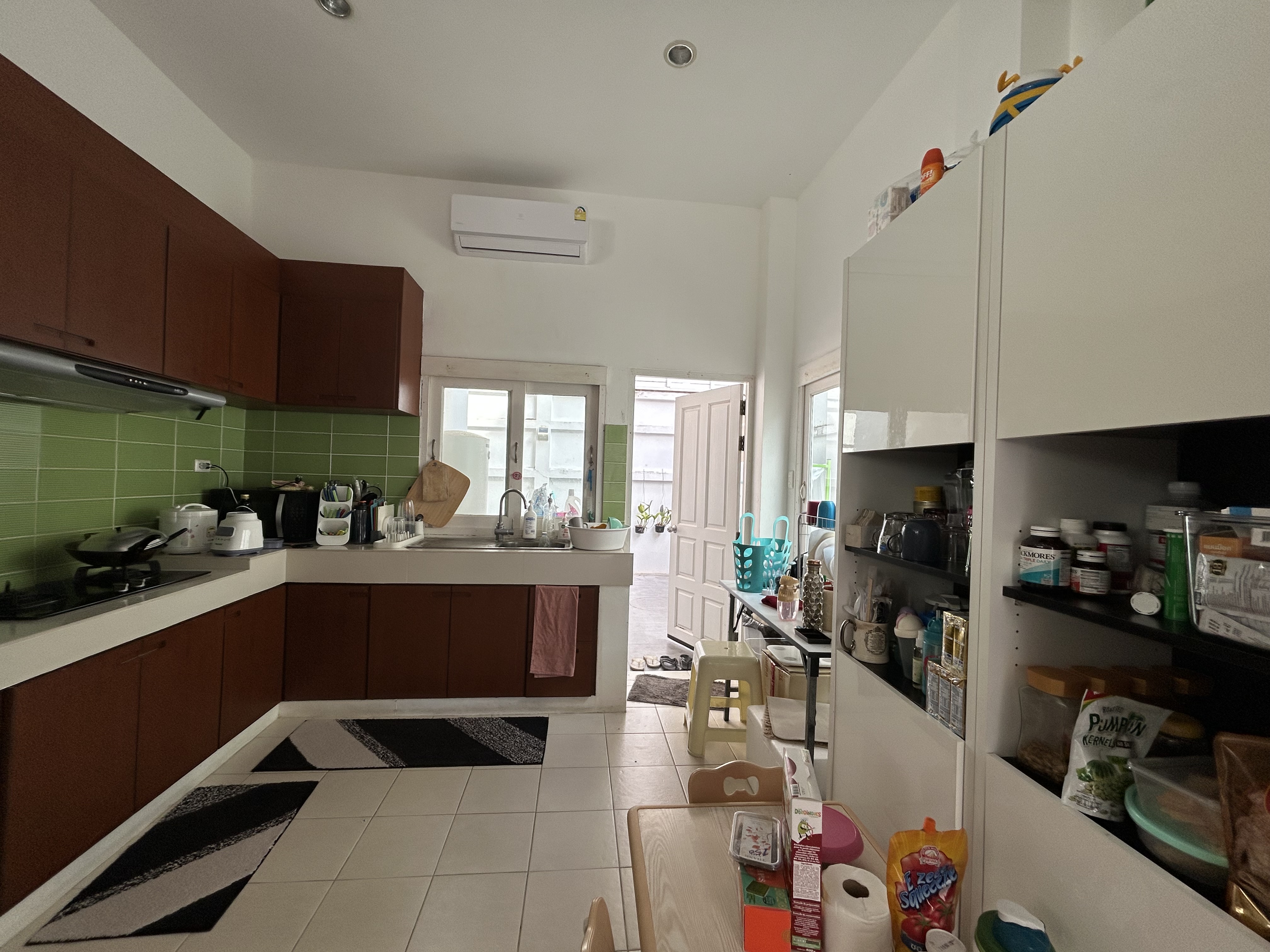 Kitchen  - Green tiled backsplash, modern kitchen design, wooden cabinets, stainless steel range hood, white countertop
