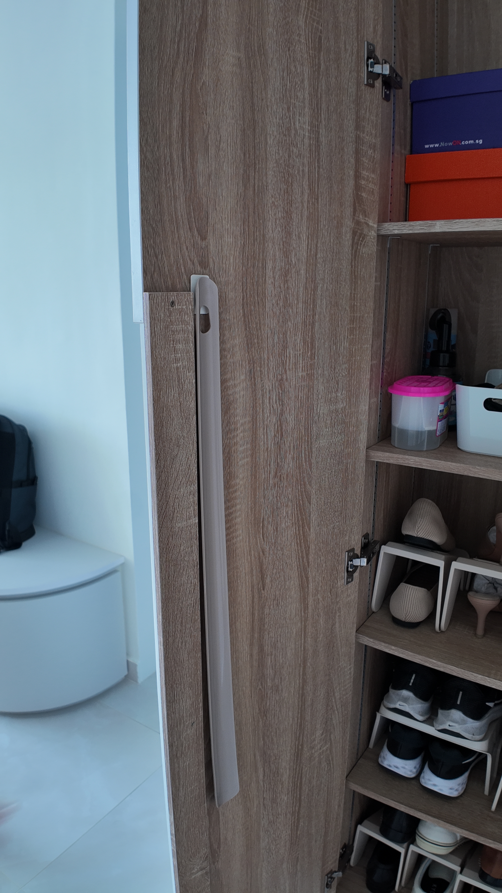 Functional Storage Solutions: A Peek into Our Simple Entryway - Wooden wardrobe door, partially open, light blue wall, black