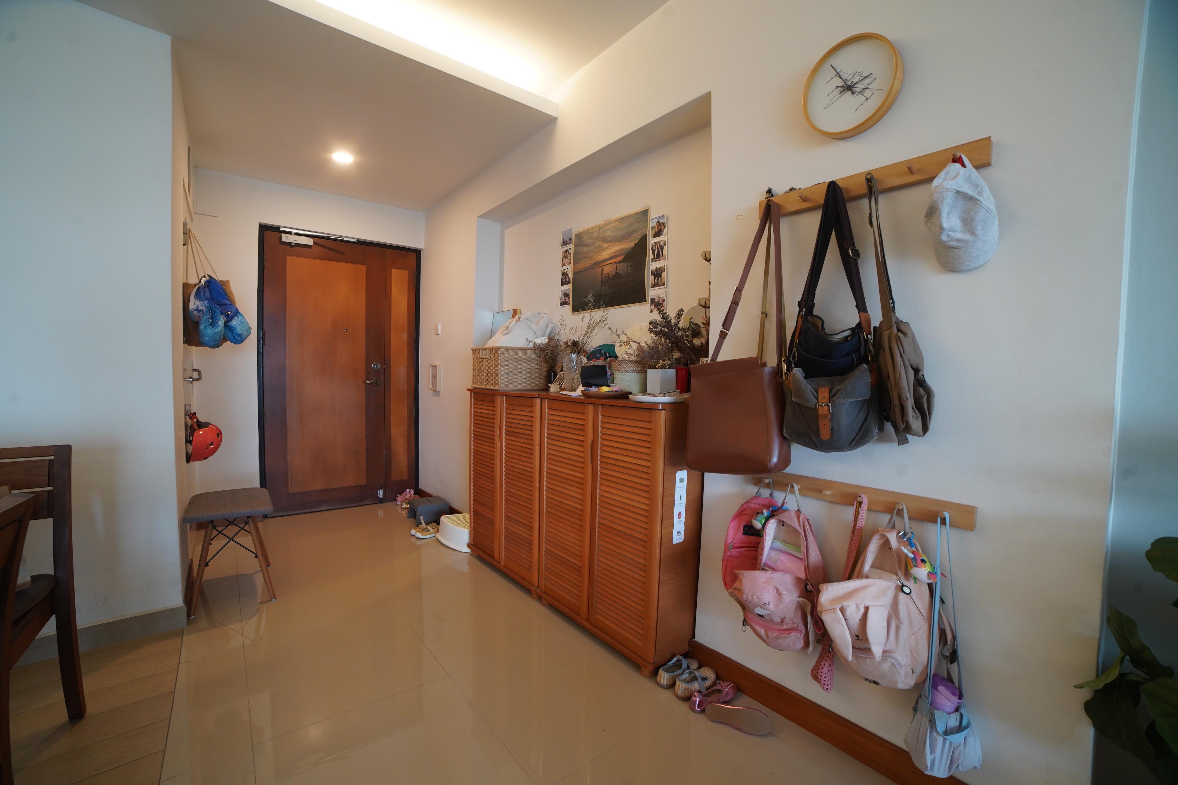 Our Entryway: A Practical Setup for Busy Families - Wooden cabinet, shoes, pink backpack, children's toys, wall clock, wooden