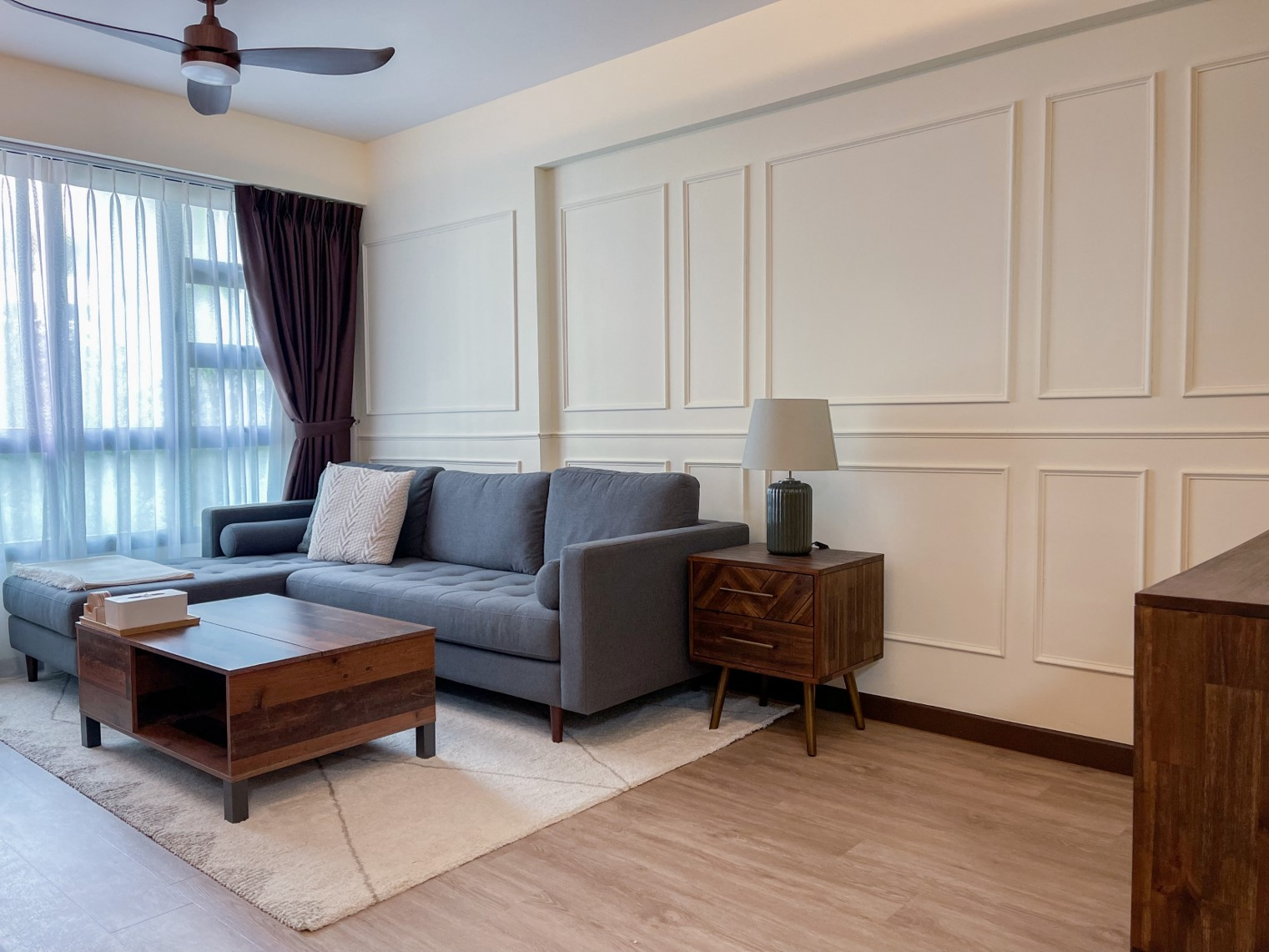 Sleek harmony in our living room - Grey sofa, wooden coffee table, beige rug, light-colored walls, white curtains, dark