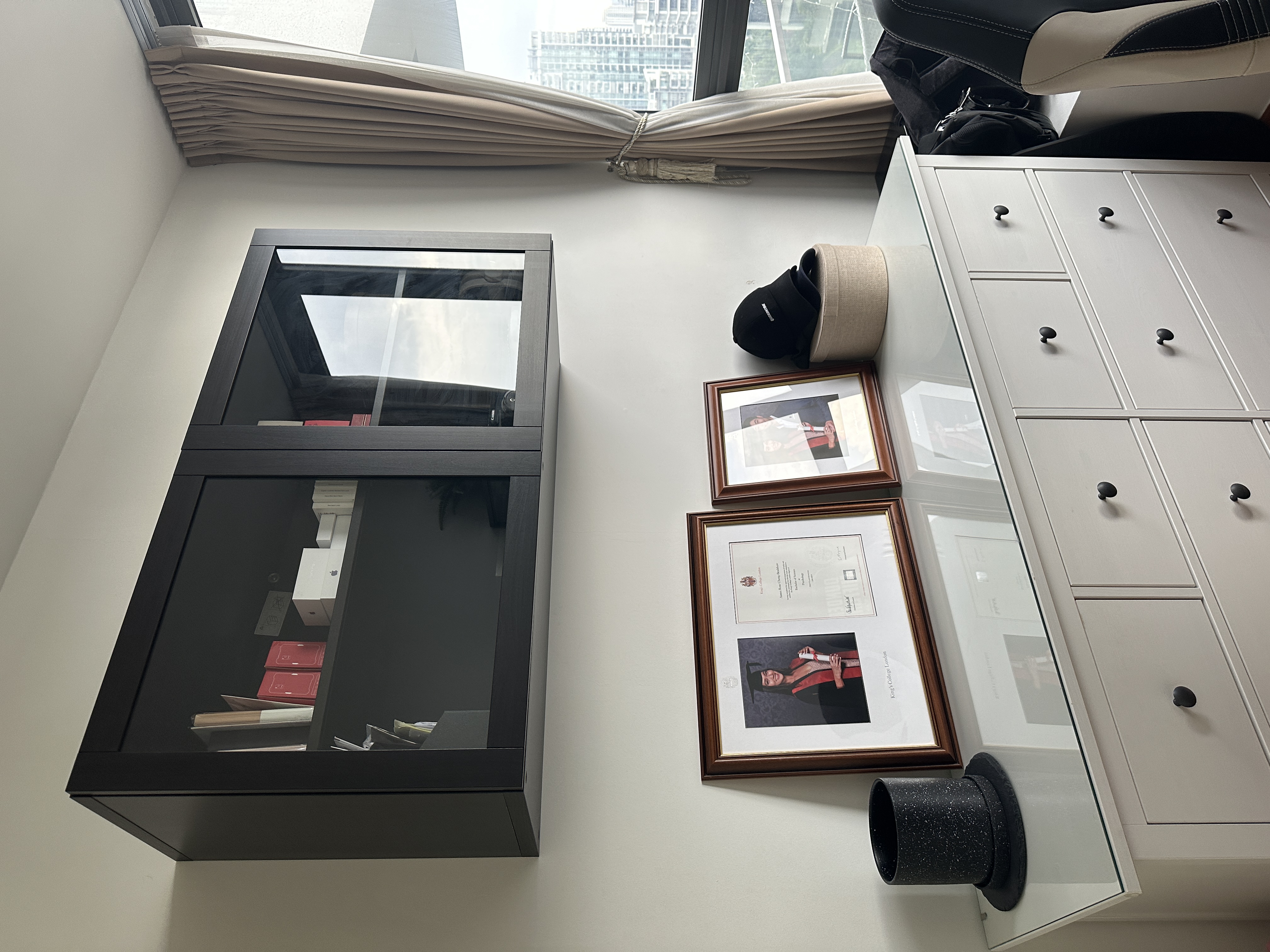 Welcome To Our Mid-Century Modern Condominium - Glass cabinet, beige curtains, black and white photo, diploma, black hat