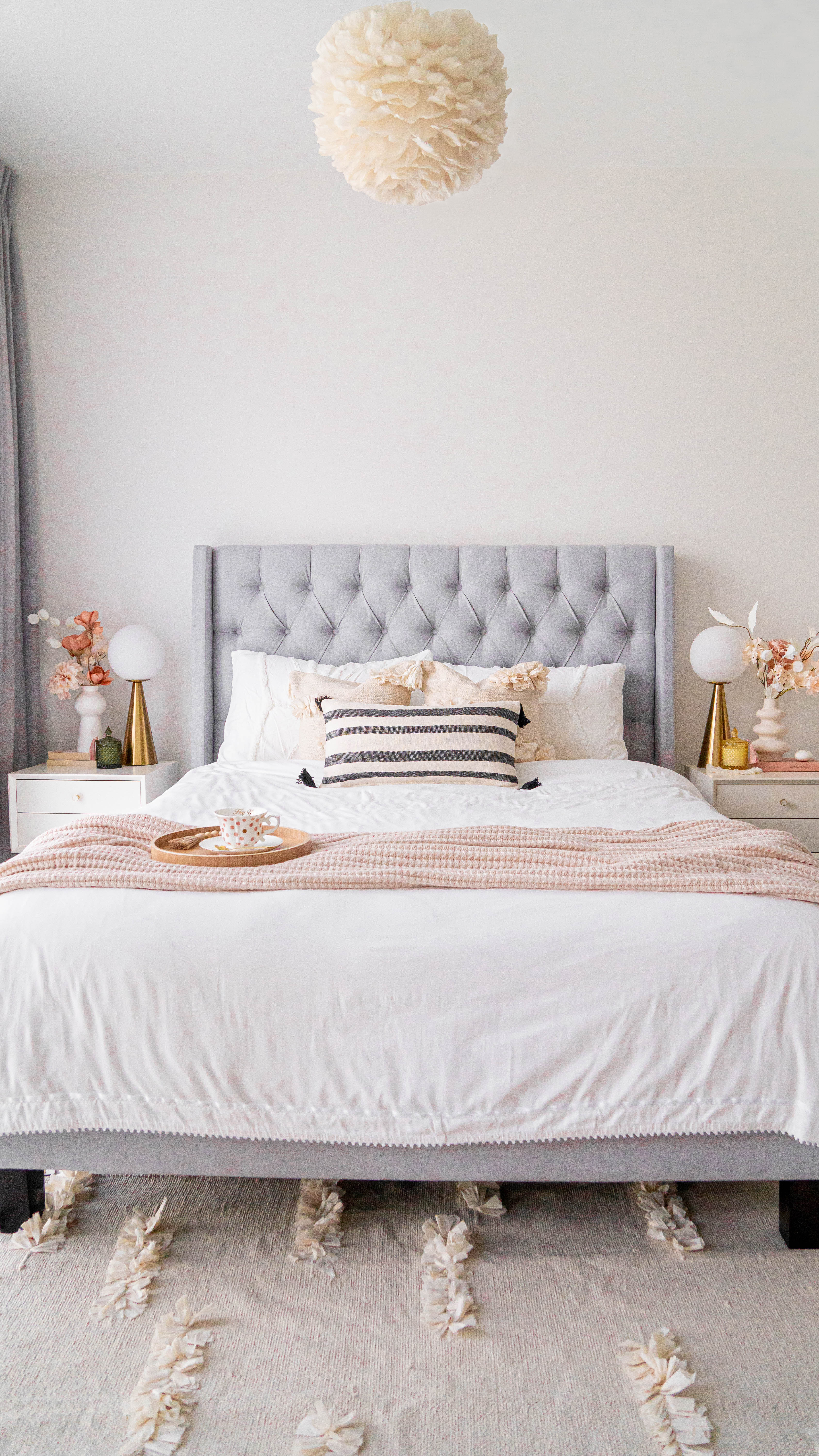Soft Elegance Dreamland - Soft, pastel-colored headboard, tufted design, white bedding, striped pillow, beige and pink throw