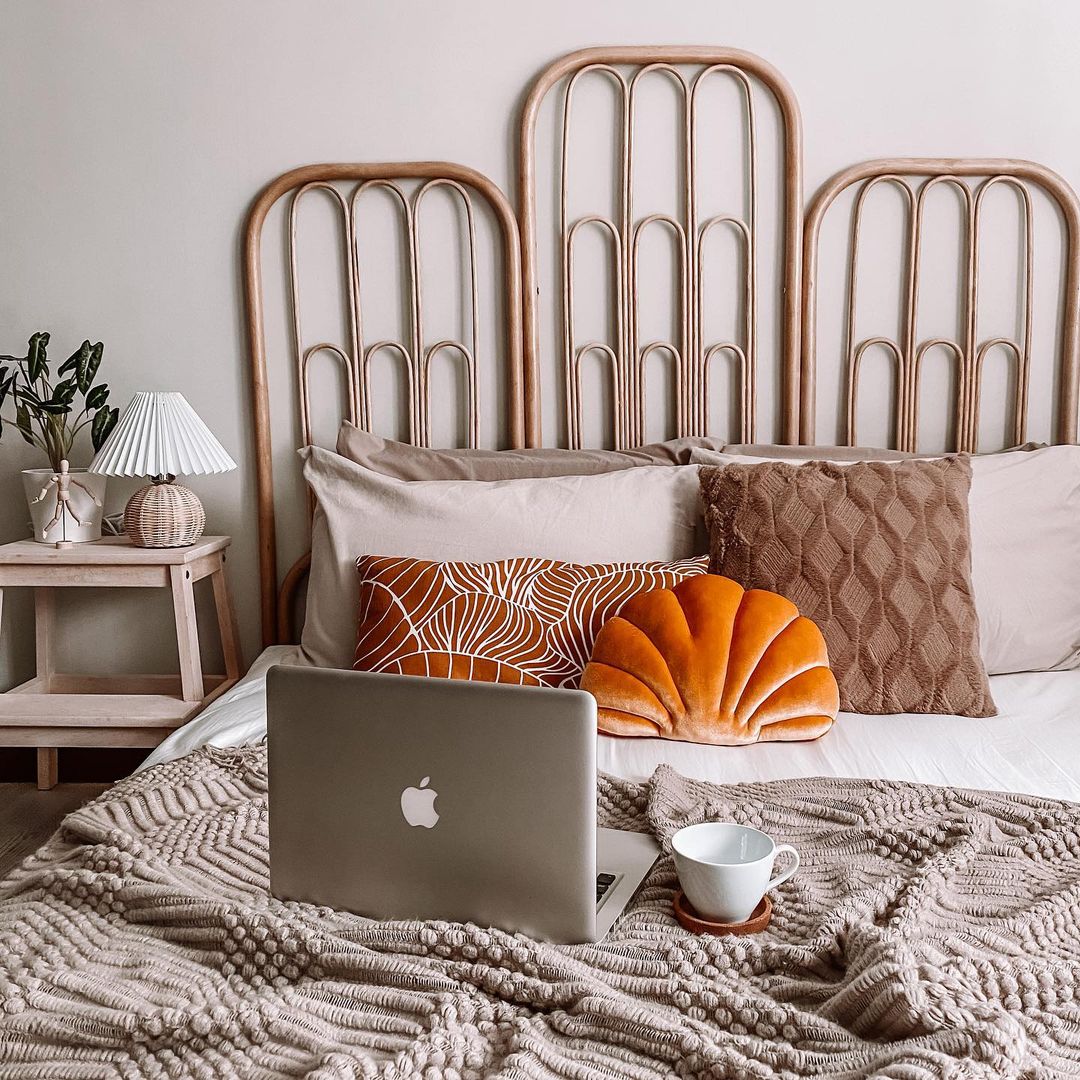 Absolute joy waking up to our Scandinavian bedroom - Wooden bed frame, beige and brown pillows, orange pumpkin cushion