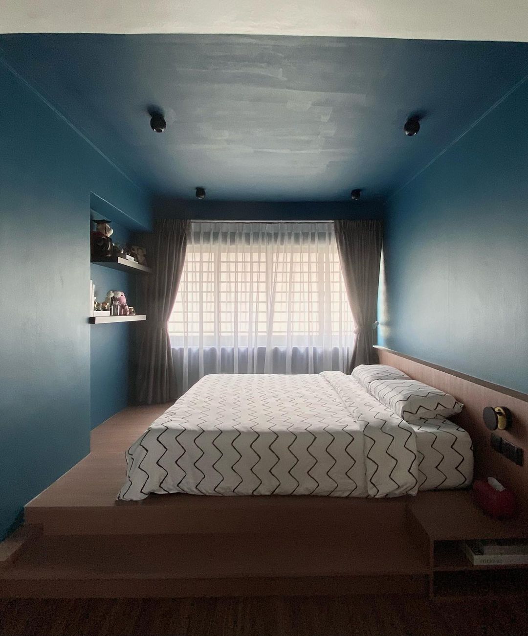 Blue Bliss Bedroom - Blue-painted walls, modern design, cozy bedroom, large bed, white and black zigzag patterned bedspread