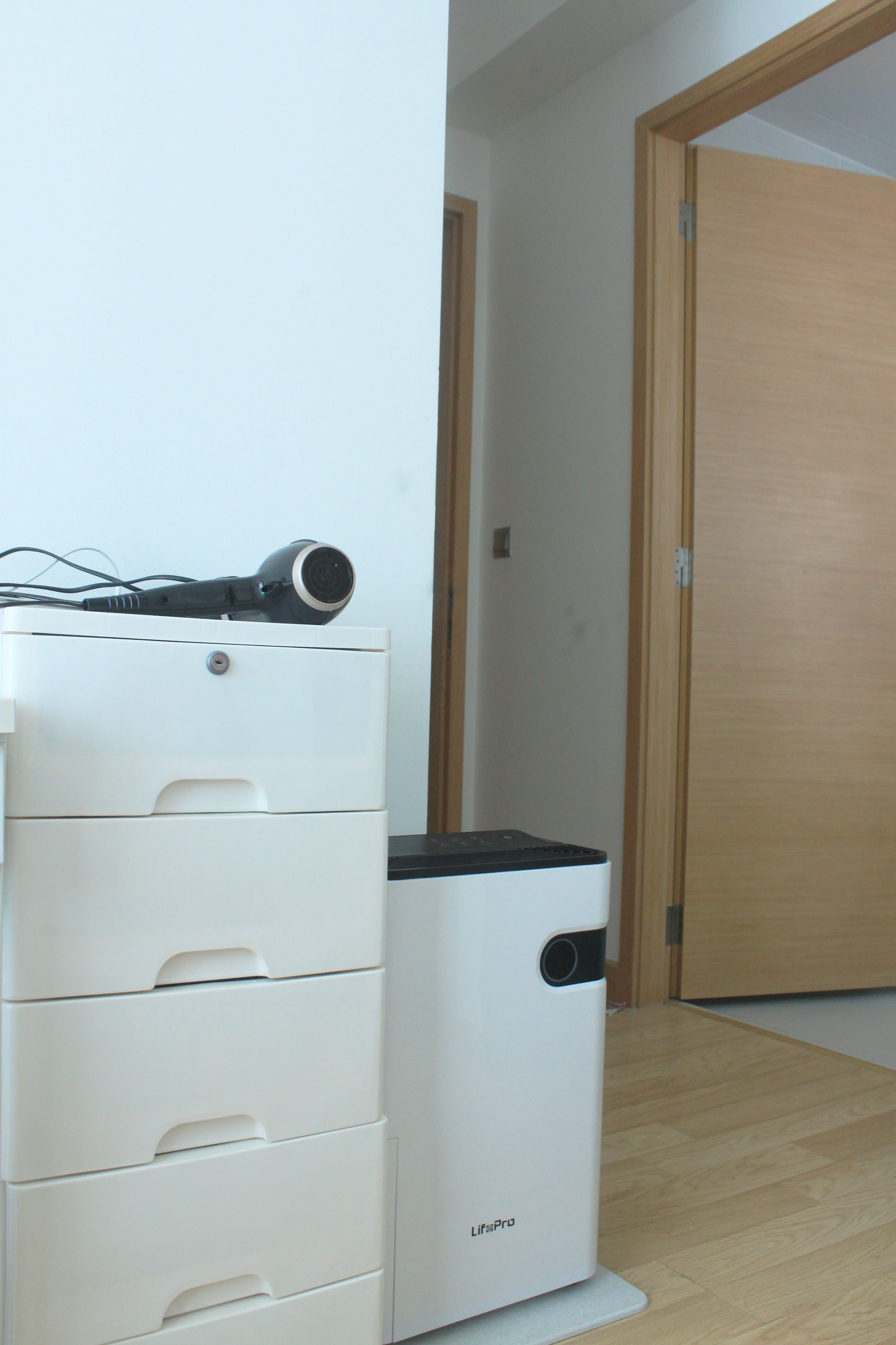 My Home Away From Home - White office drawer, black hairdryer, white filing cabinet, wooden door, light blue wall, white