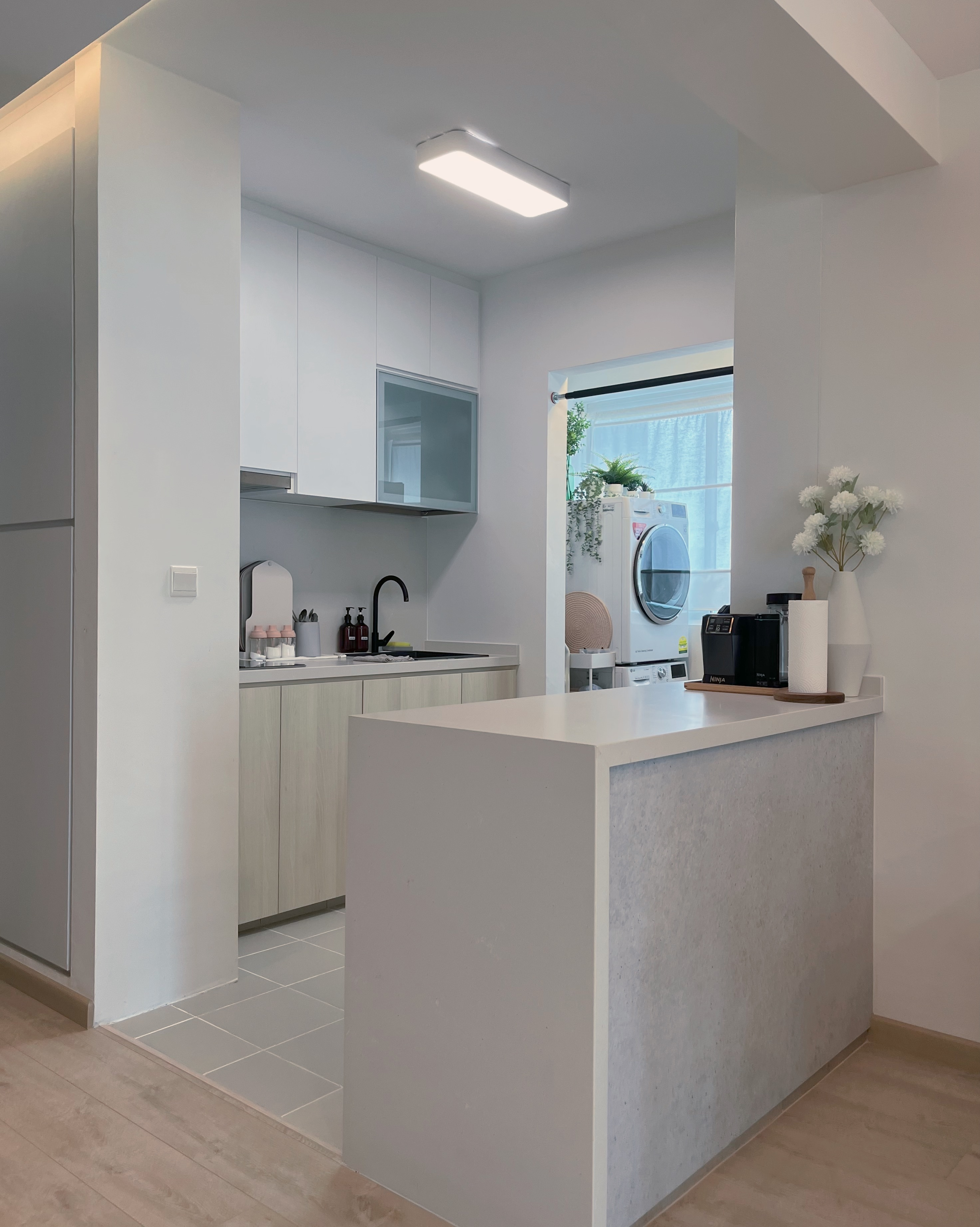 Living In A Cosy 3-room Flat with Minimal Housekeeping - Modern kitchen with sleek white cabinets, minimalist design, open