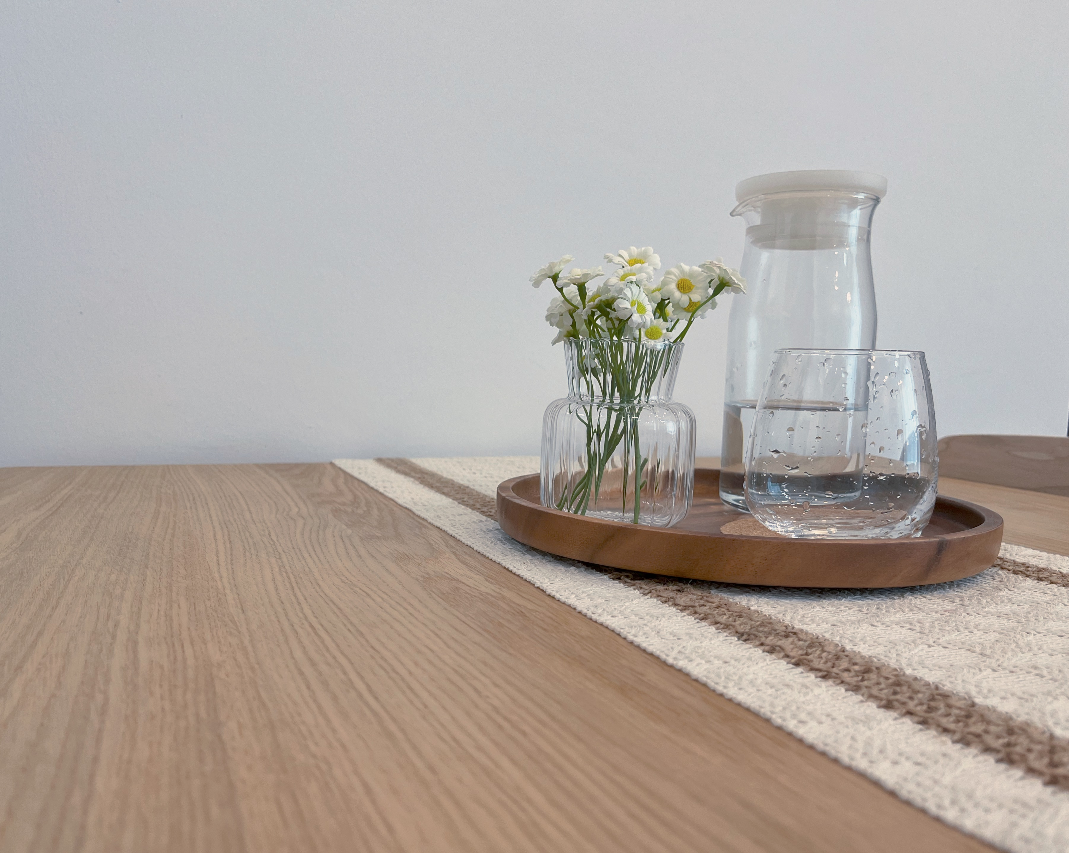 Living In A Cosy 3-room Flat with Minimal Housekeeping - Clear glass vase, white flowers, wooden tray, beige rug, light