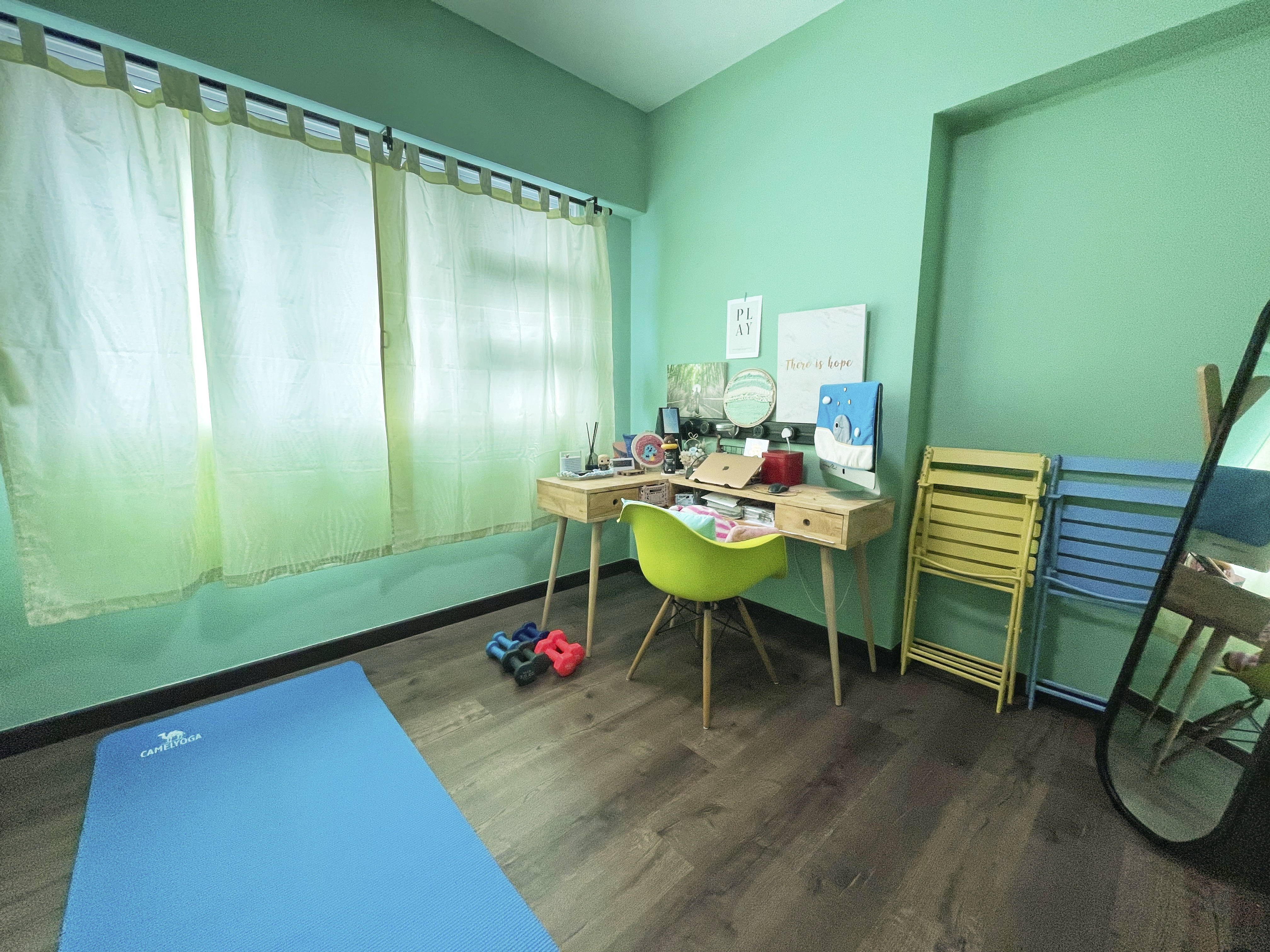 Our Colourful Personalities Imprinted On Our Apartment - Green walls, wooden desk, blue yoga mat, yellow and blue folding