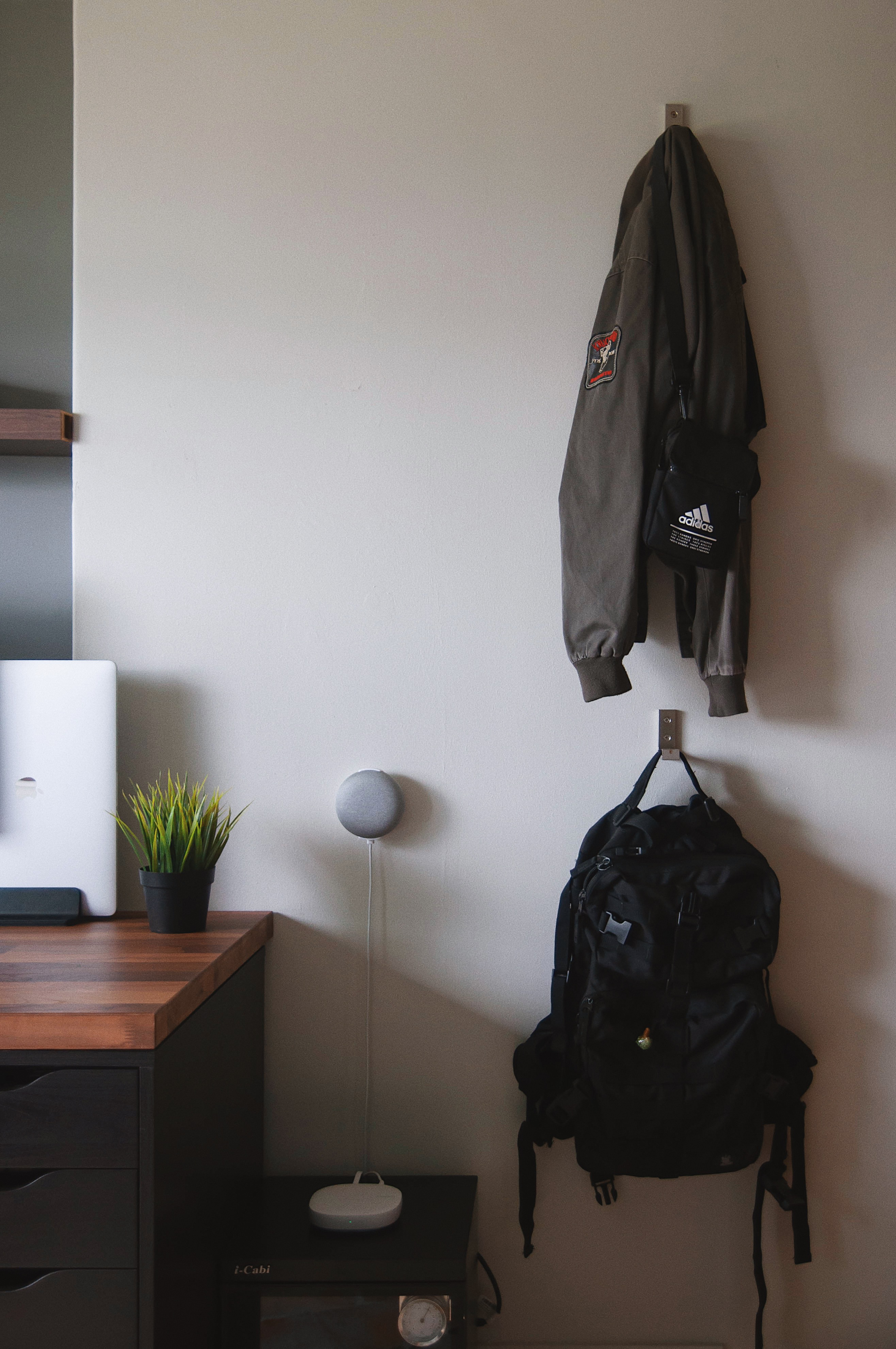 A Graphic Designer’s Humble Abode - Desk, laptop, potted plant, white chair, gray lamp, black backpack, black desk drawer