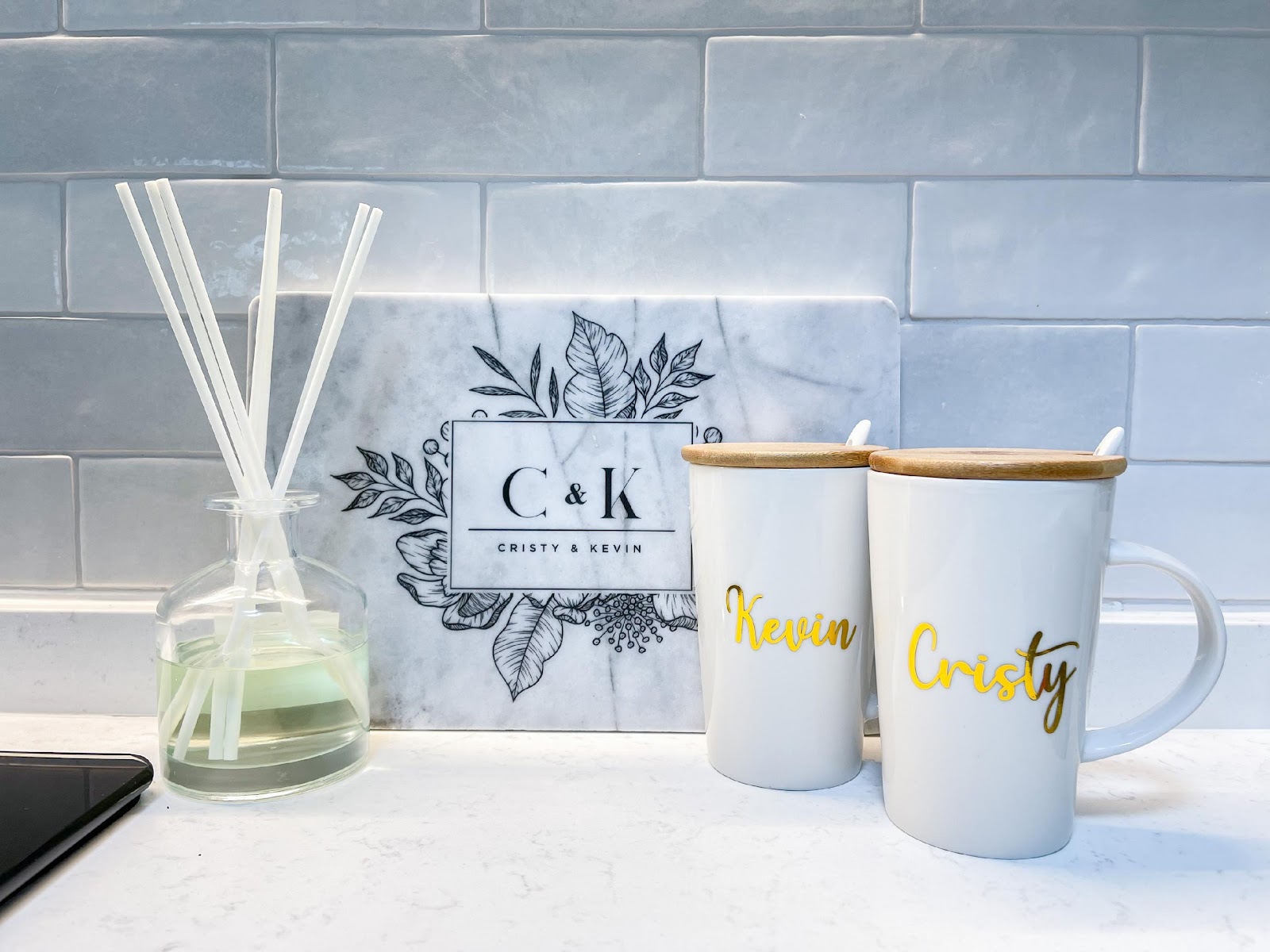 Modern Home for the Modern Interracial Couple - Clear glass vase with white cotton swabs, marble backsplash, black and white