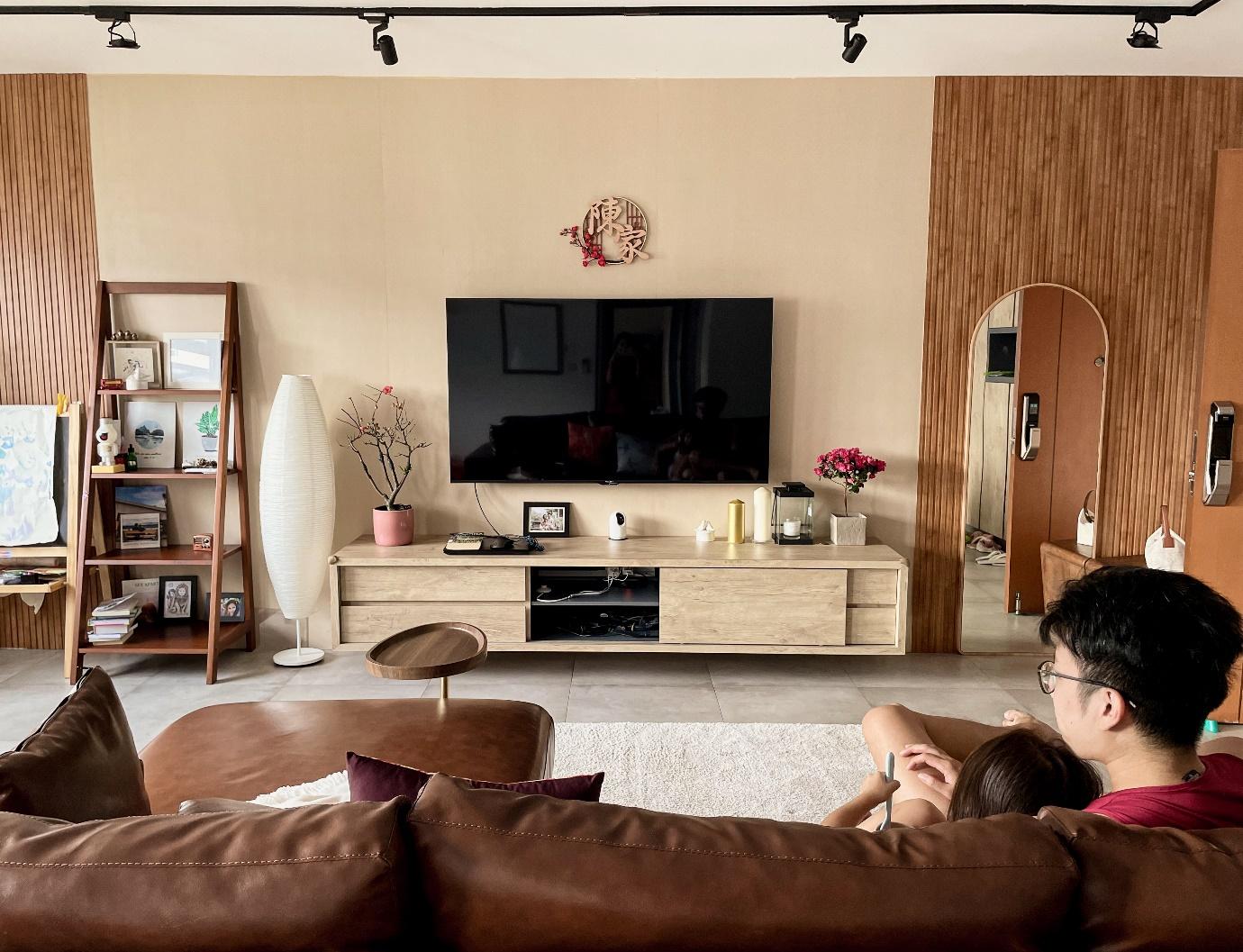 This is Home, Truly - Modern living room, cozy atmosphere, wooden furniture, large flat-screen TV, minimalist decor, brown