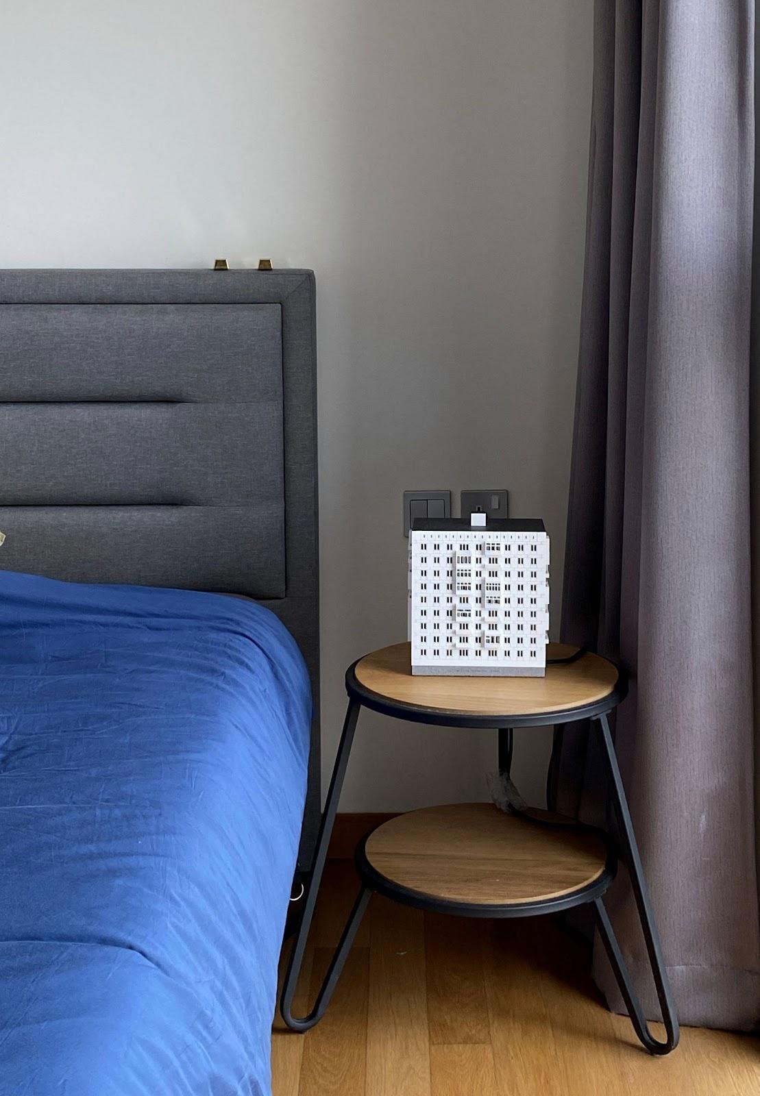 A Photographer's One-Room Studio Man Cave - Grey upholstered headboard, blue bedspread, wooden bedside table, modern design