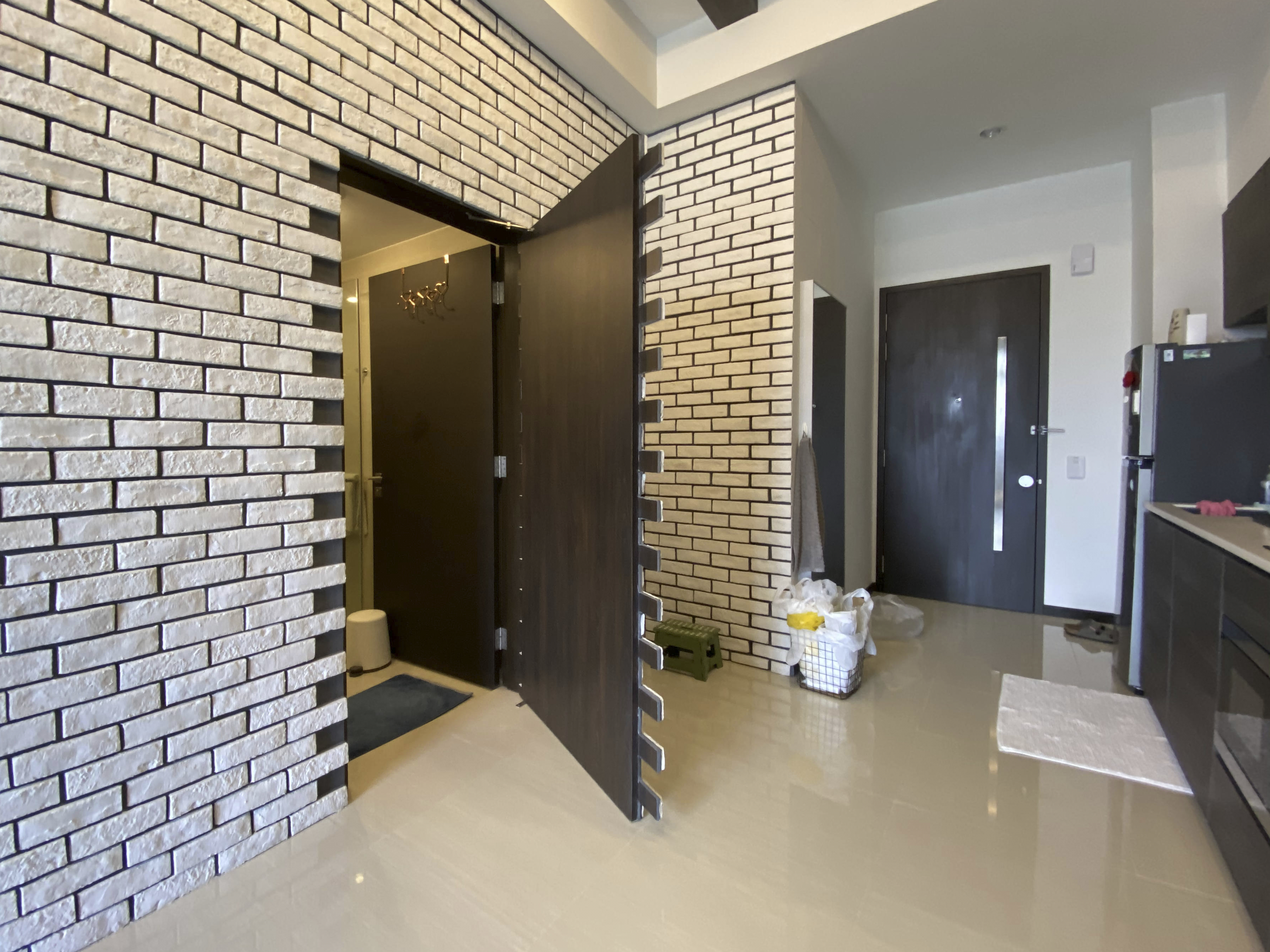 Our Smart Apartment That Might Be Smarter Than Us - White brick wall, modern kitchen, open door, laundry basket, trash can