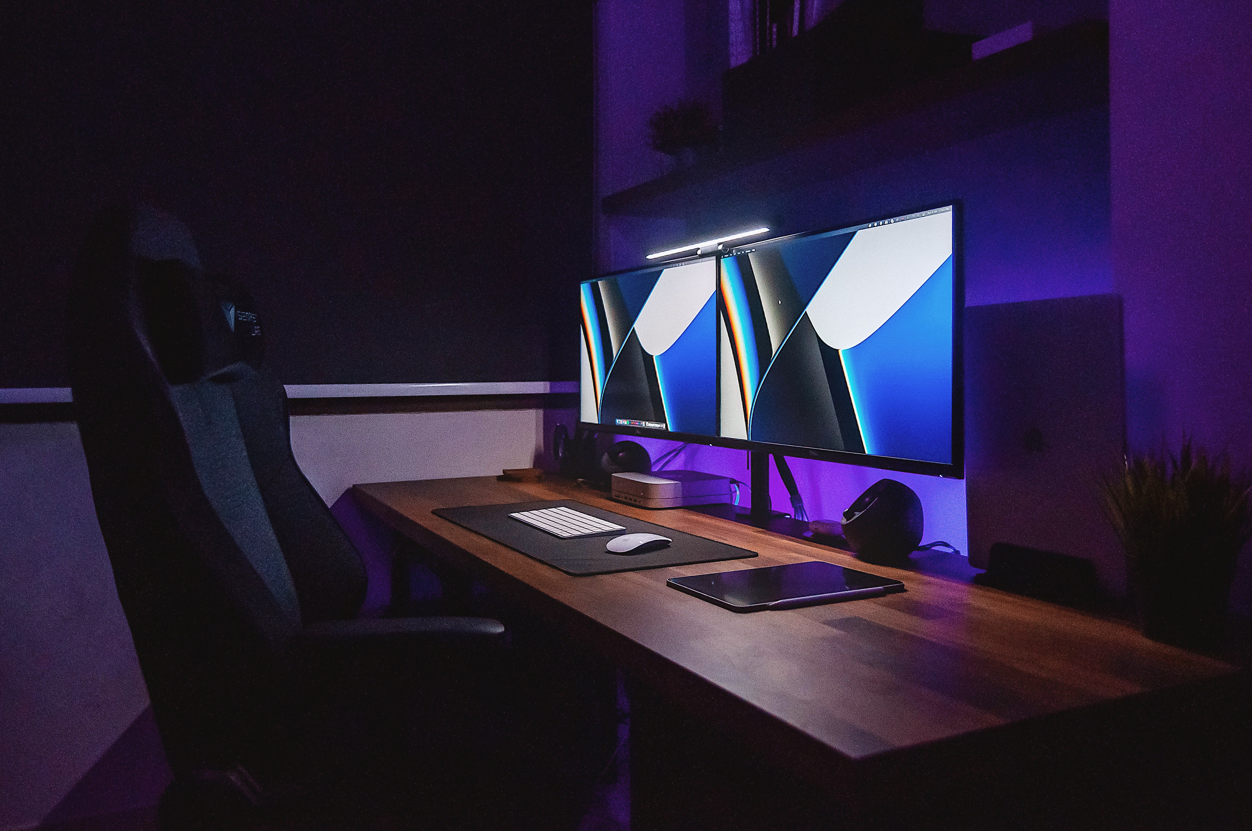 A Graphic Designer’s Humble Abode - Modern workspace, dual monitors, dim lighting, ergonomic chair, sleek design
