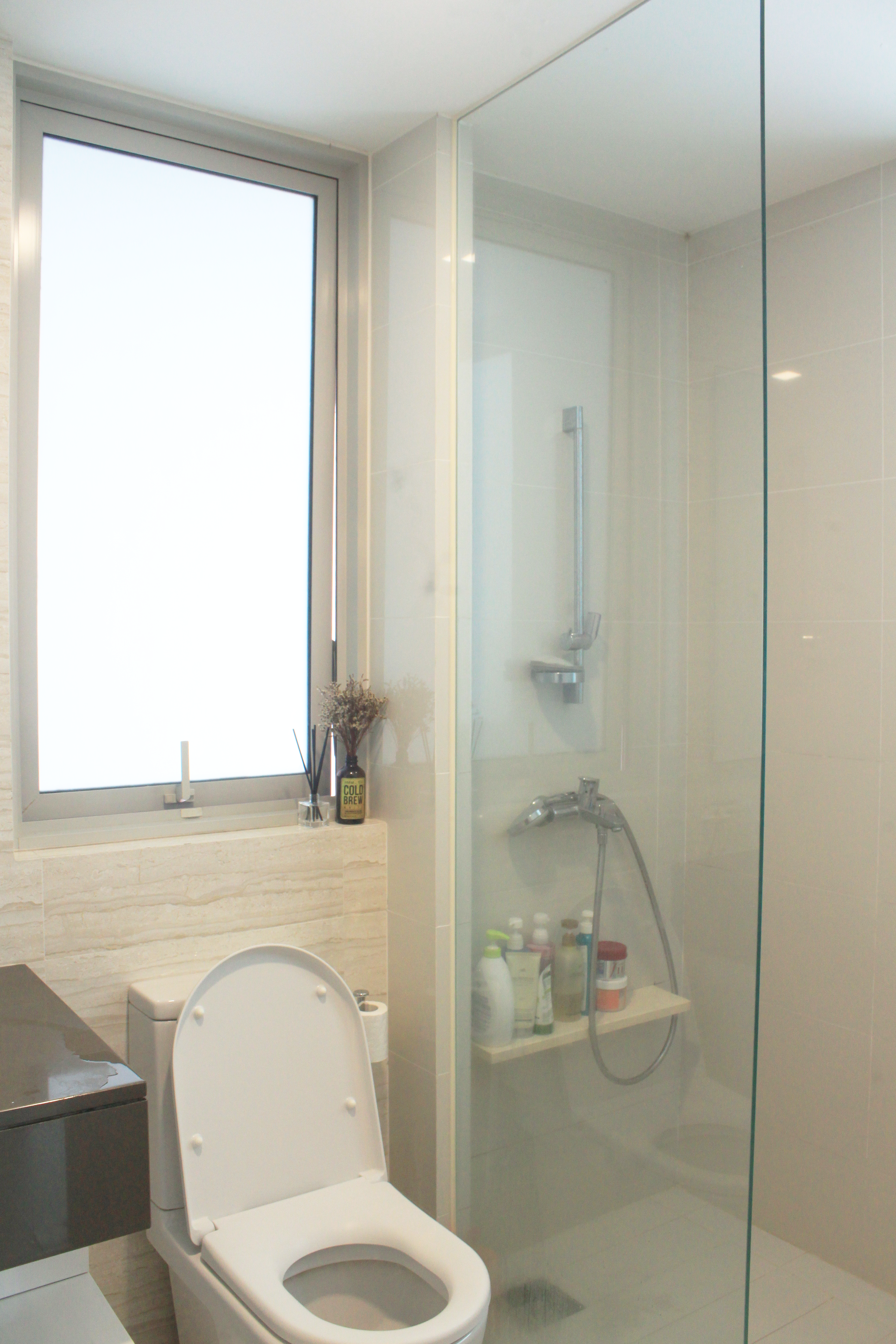 My Home Away From Home - Modern bathroom, glass shower enclosure, white tiled walls, large window, frosted glass, toilet