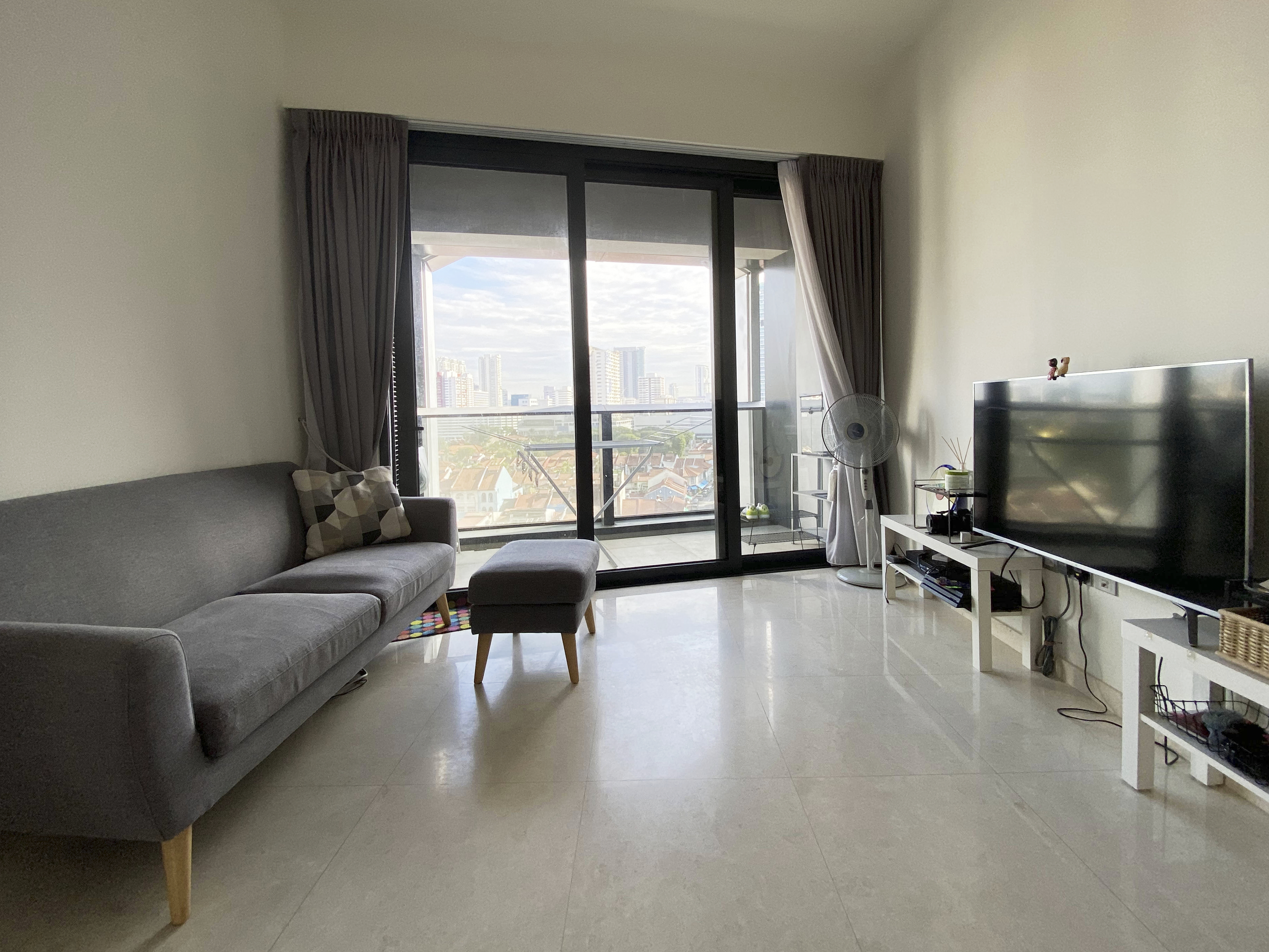 A Photographer's One-Room Studio Man Cave - Modern living room with gray sofa, wooden legs, and geometric patterned cushions.