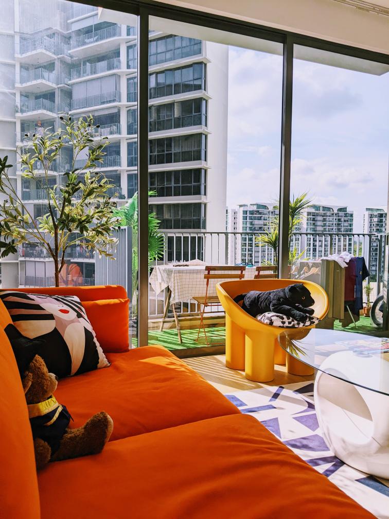 Bright colours are my jam - Orange sofa, black and white pillows, teddy bear, modern decor, glass coffee table, balcony view