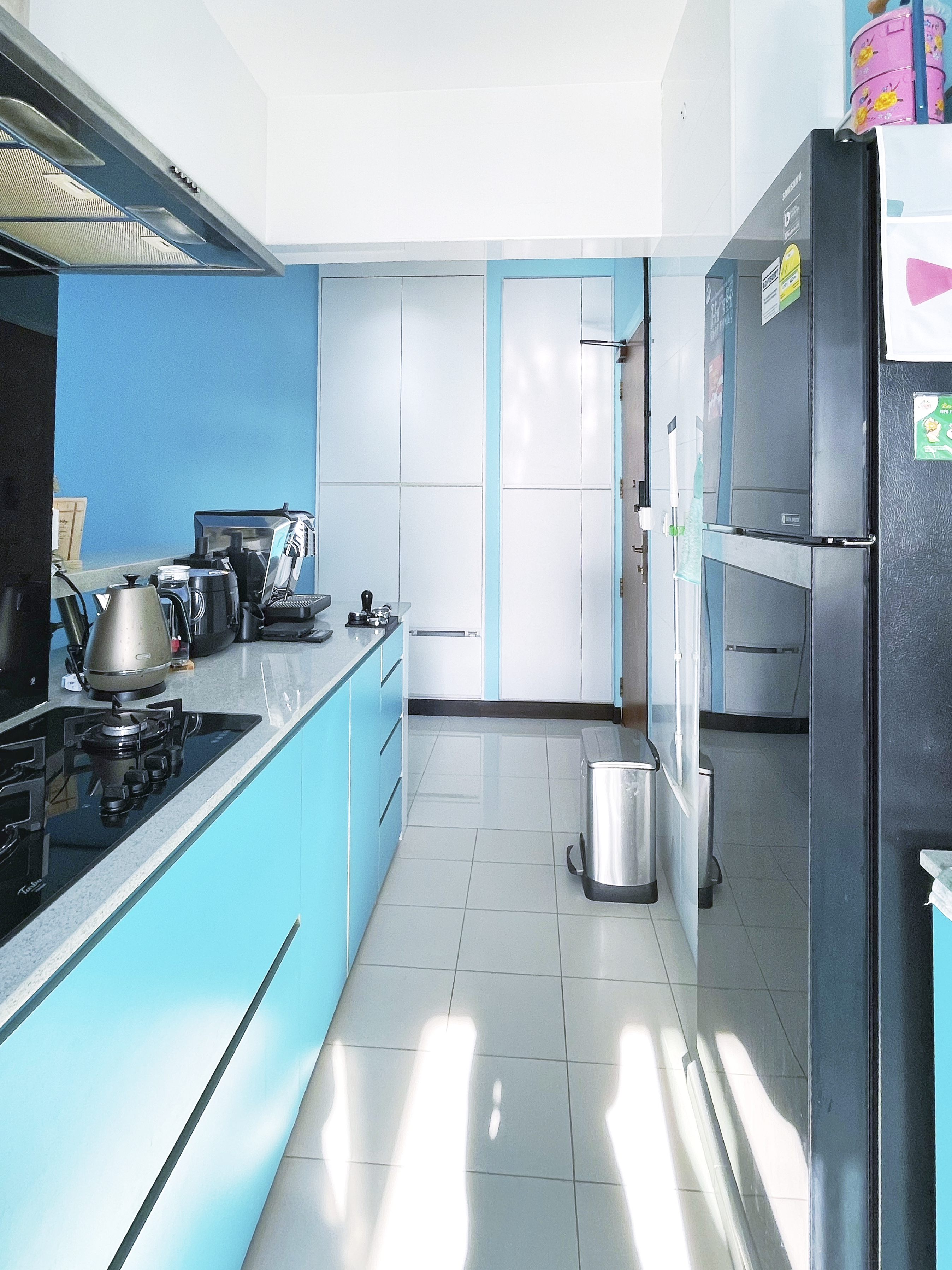 Our Colourful Personalities Imprinted On Our Apartment - Blue kitchen cabinetry, modern appliances, stainless steel kettle