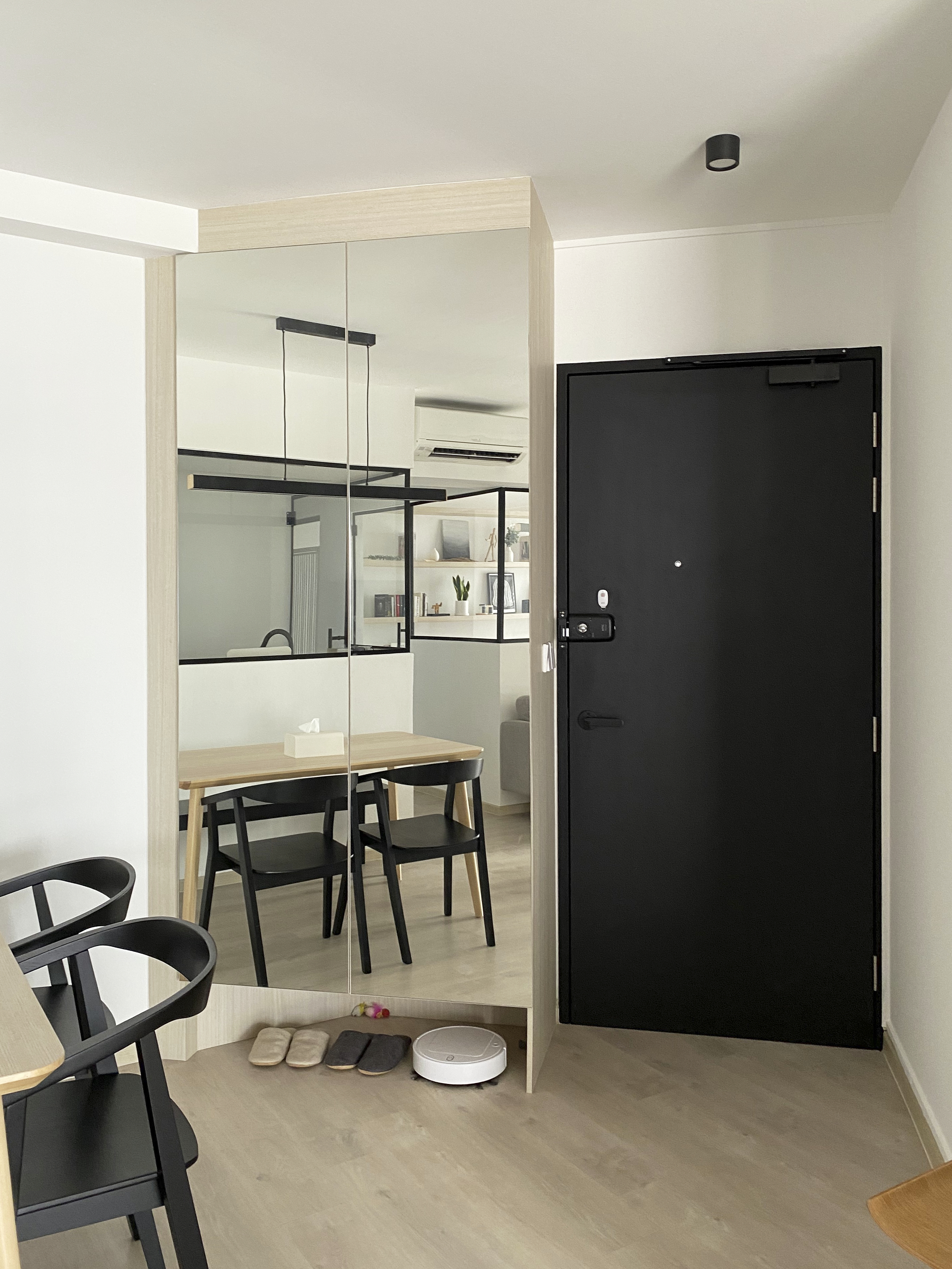 A Minimalist Apartment with an Urban Jungle - Modern minimalist dining room, sleek black furniture, wooden dining table