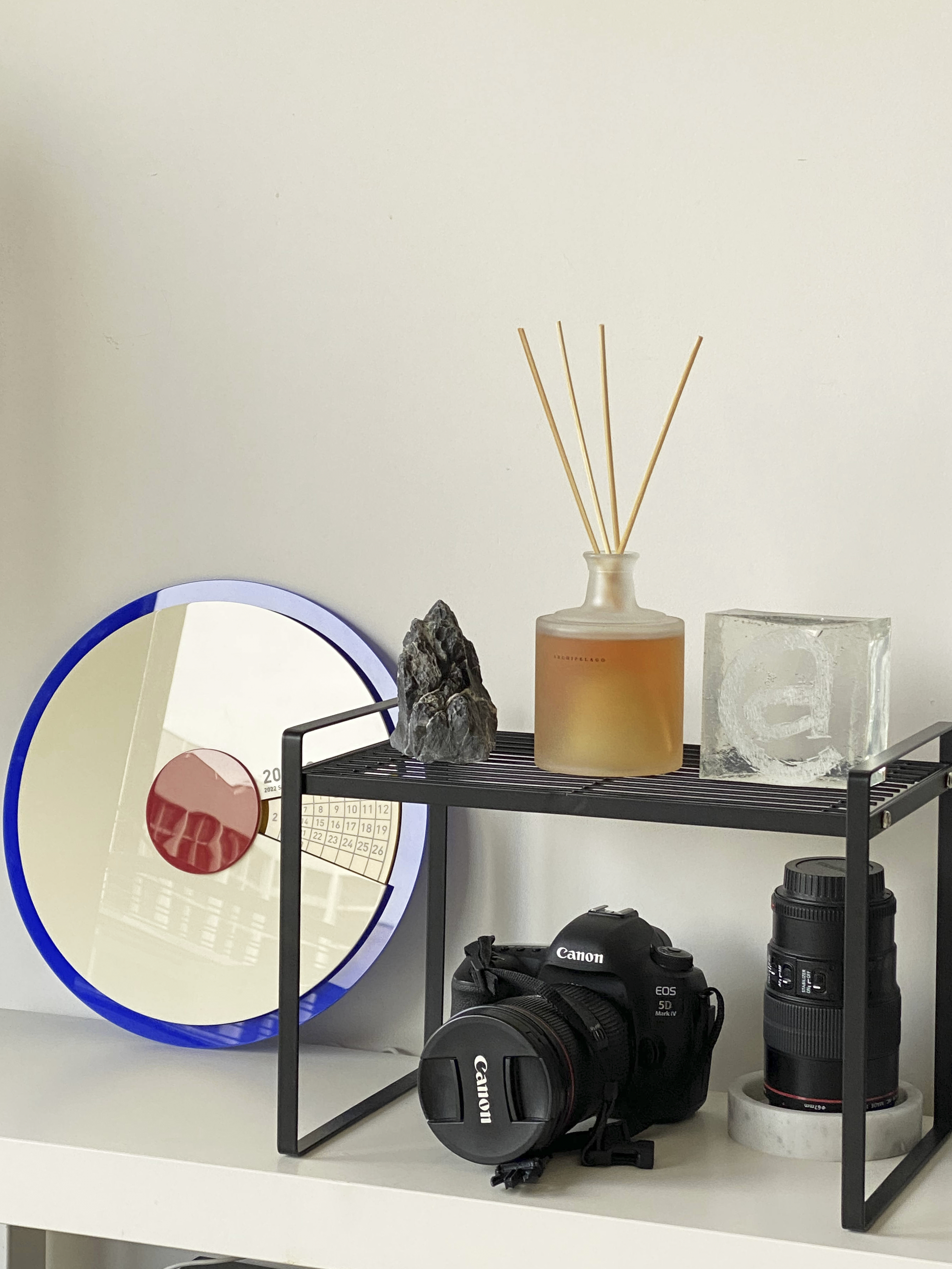 A Photographer's One-Room Studio Man Cave - Calender, glass, rock, candle, glass jar, incense sticks, camera, Canon, lens