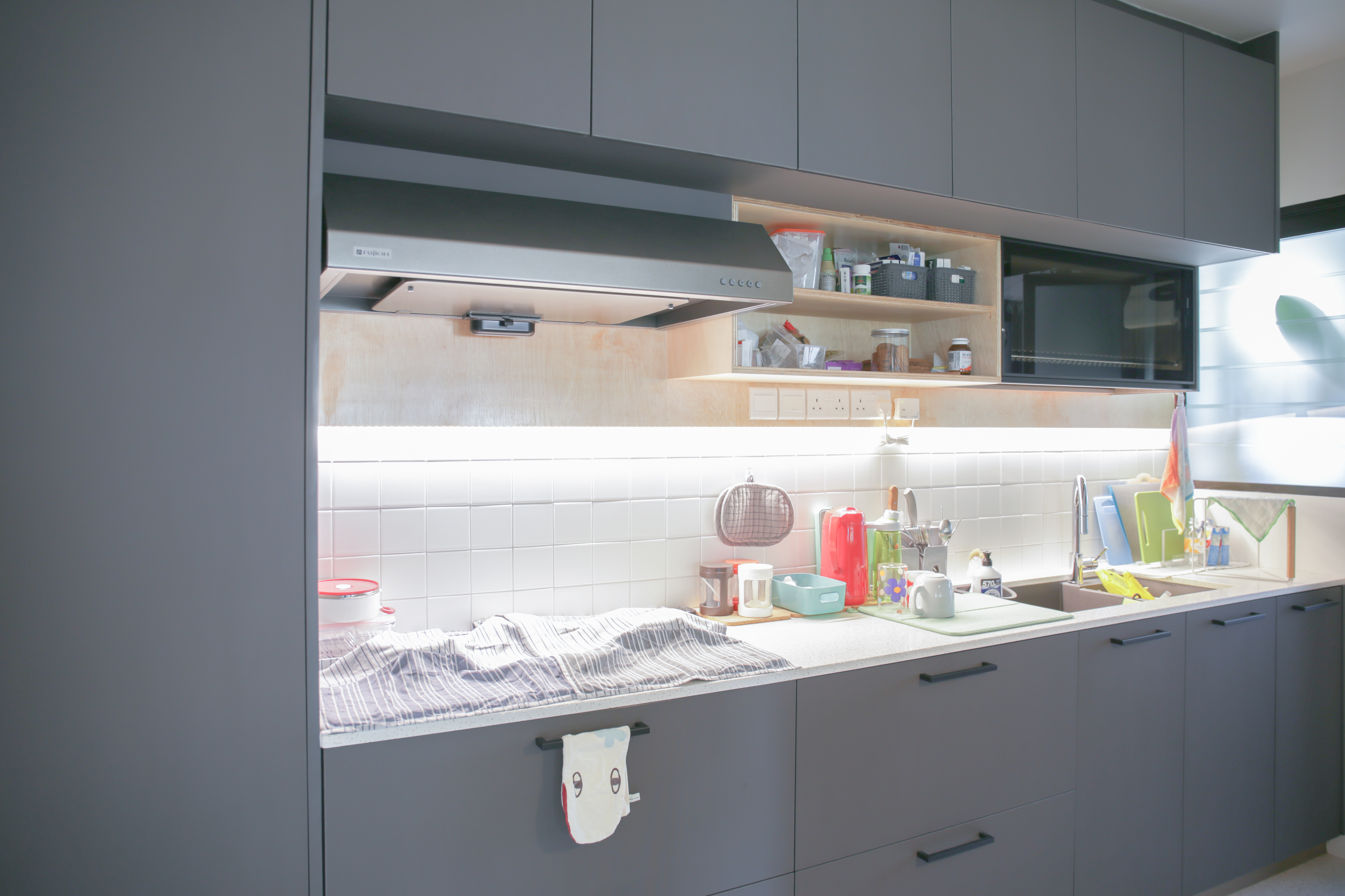 The Eccentricity of an Artistic Couple’s Apartment - Gray kitchen cabinets, modern design, open shelves, white tiled