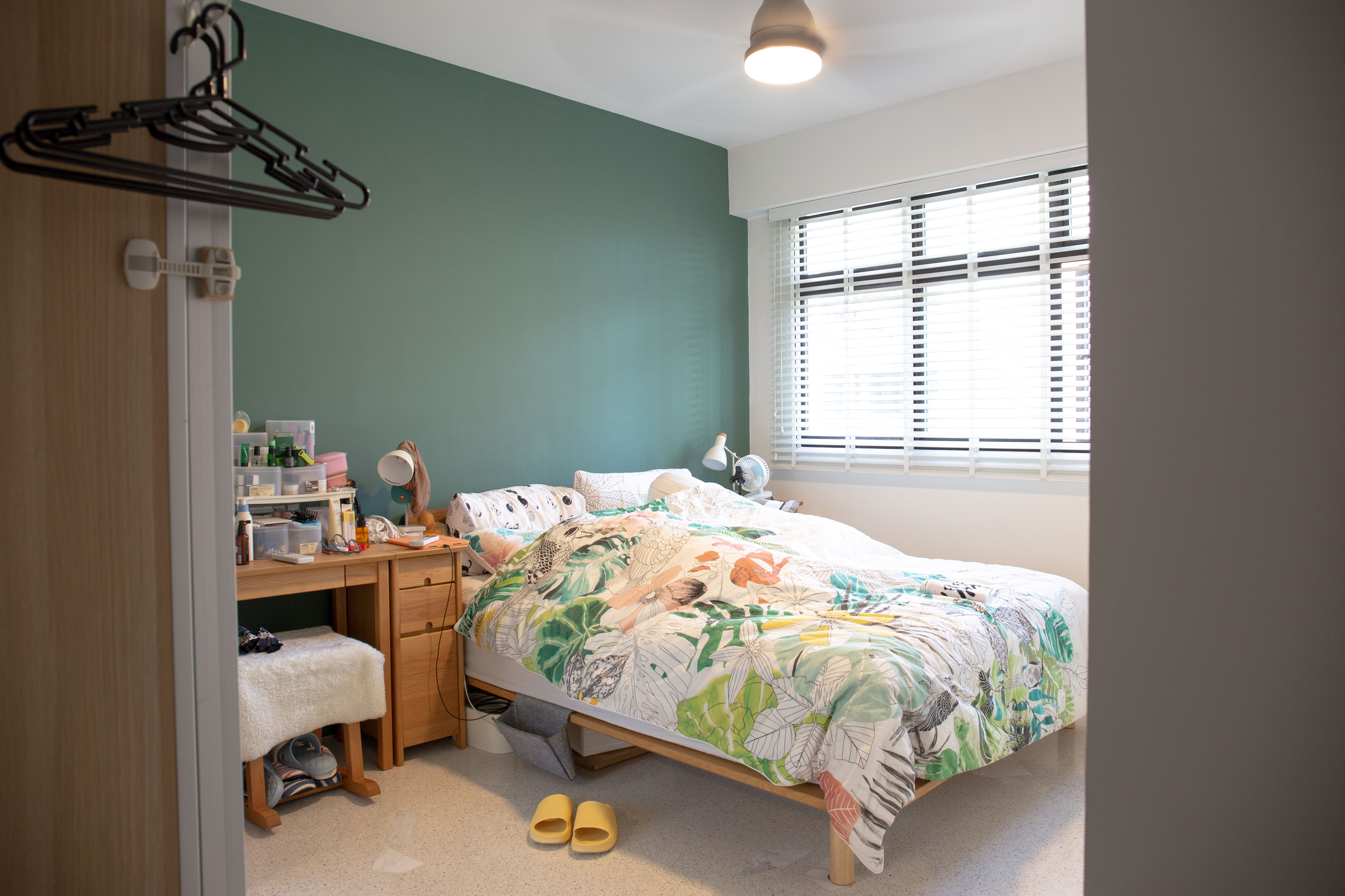 The Eccentricity of an Artistic Couple’s Apartment - Green wall, bedroom, desk, wardrobe, nightstand, bed, floral bedspread