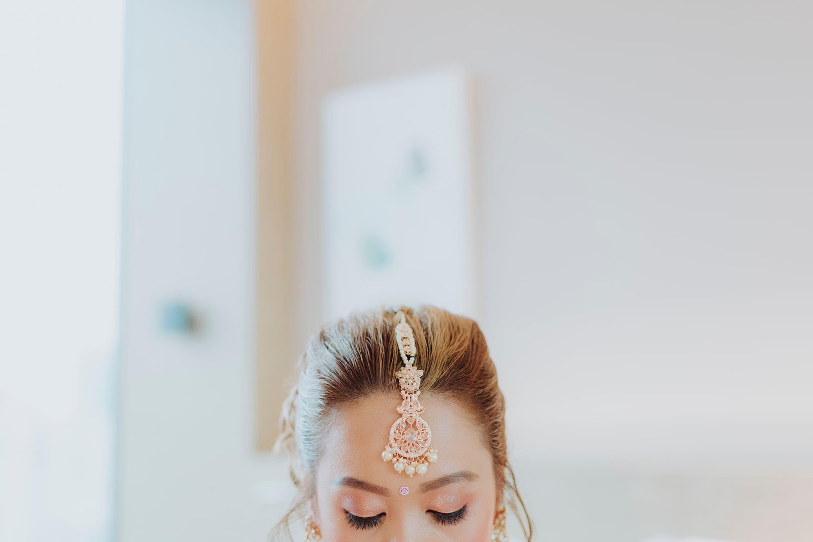 Modern Home for the Modern Interracial Couple - Indian bridal headpiece, elegant jewelry, soft lighting, serene expression