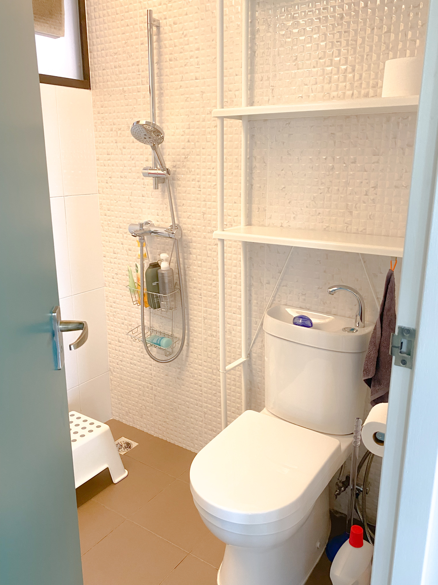 The Eccentricity of an Artistic Couple’s Apartment - White bathroom, tiled walls, shower area, white toilet, white sink